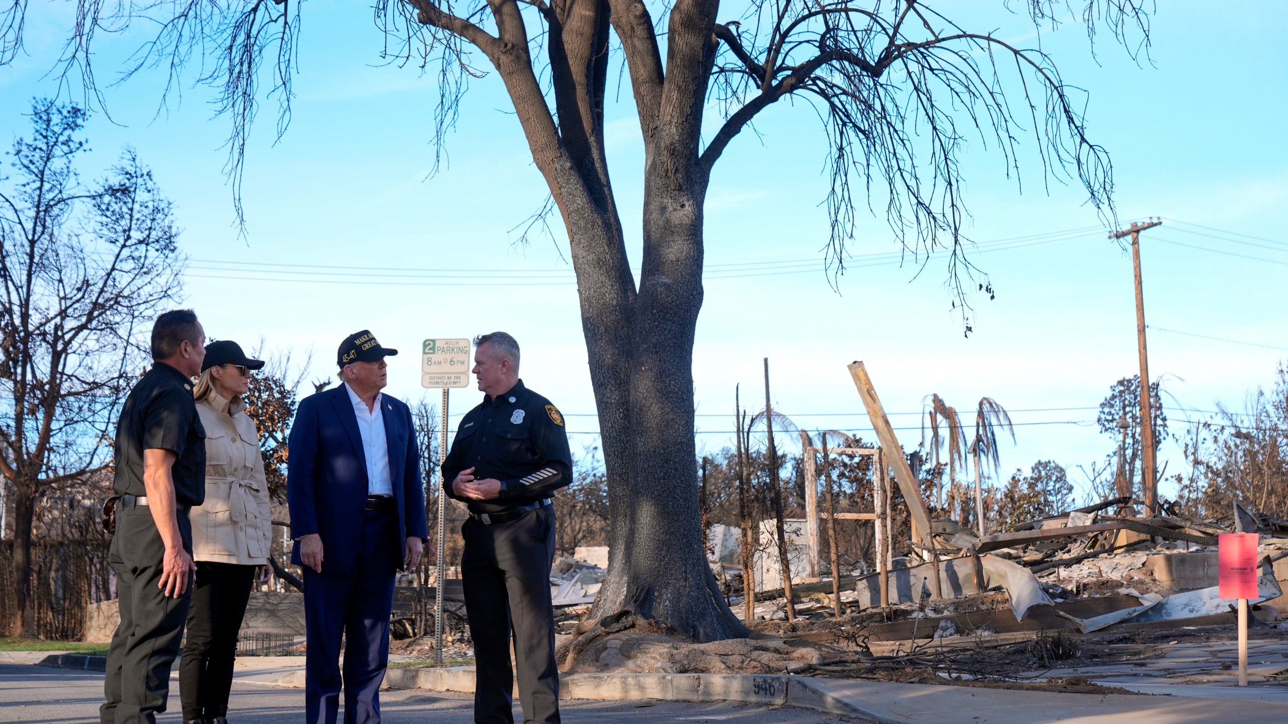 FILE - President Donald Trump and first lady Melania Trump walk with Jason Hing, chief deputy of emergency services at the Los Angles Fire Department, left, and Capt. Jeff Brown, chief of Station 69, as they tour the Pacific Palisades neighborhood affected by recent wildfires in Los Angeles, Jan. 24, 2025. (AP Photo/Mark Schiefelbein, File)