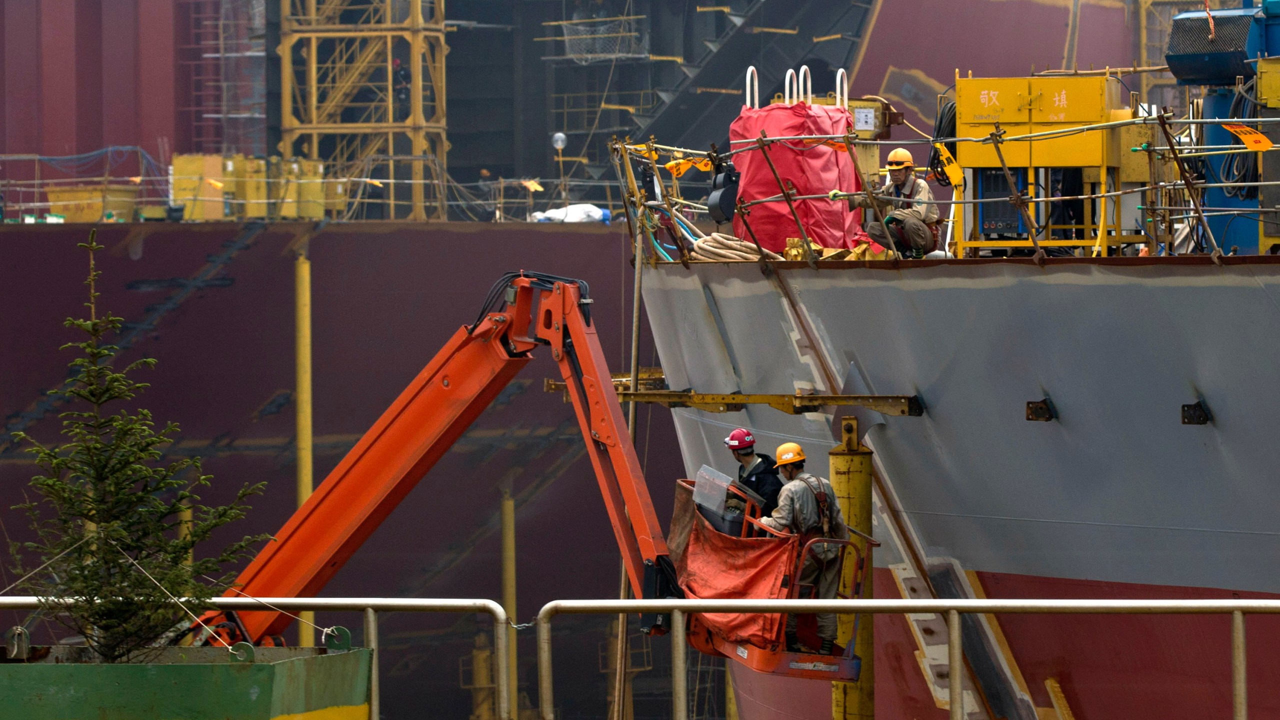 FILE - Workers construct the hull of a vessel at the STX shipbuilding plant on Changxing Island, on the outskirt of Dalian, in northeast China's Liaoning province, Sept. 15, 2011. (AP Photo/Andy Wong, File)
