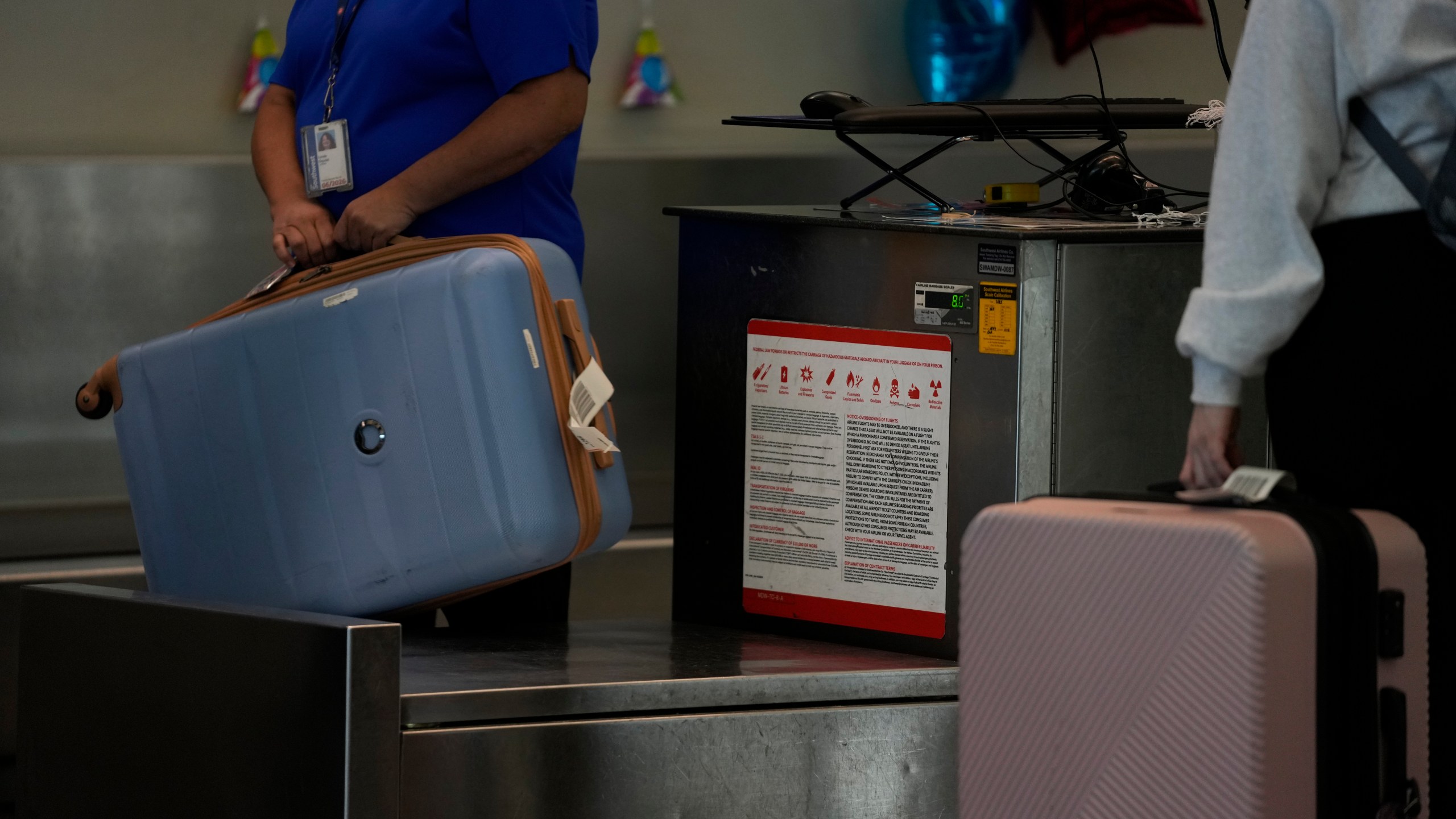 A Southwest Airlines traveler checks a bag at Midway International Airport, Tuesday, March 11, 2025, in Chicago. (AP Photo/Erin Hooley)