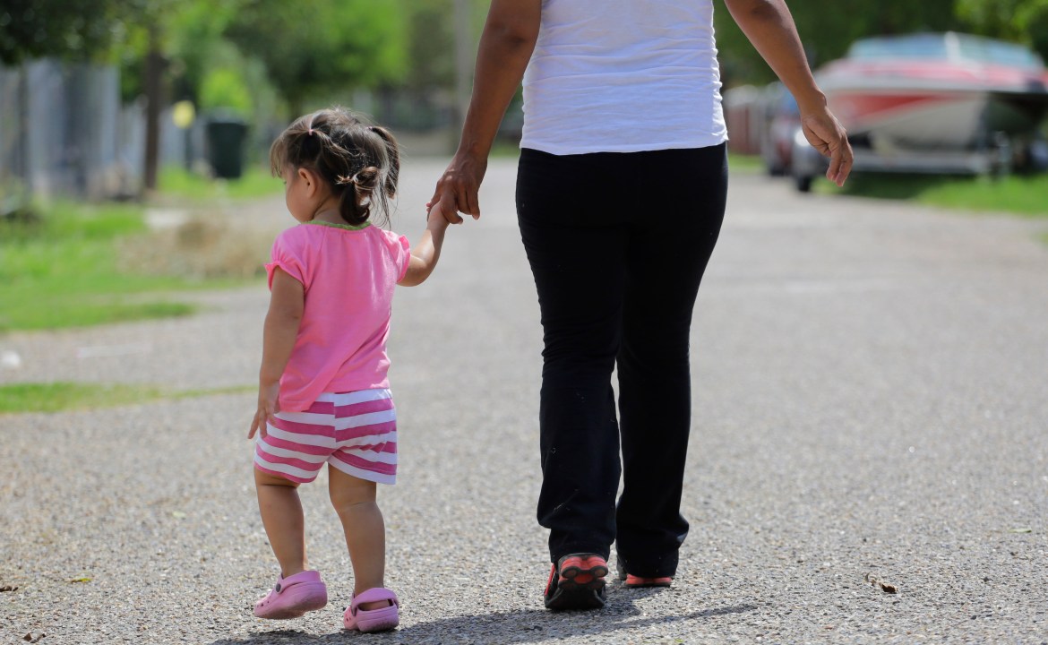 FILE - In this Sept. 16, 2015, photo, a woman in Sullivan City, Texas, who said she entered the country illegally, walks with her daughter who was born in the United States, but was denied a birth certificate. (AP Photo/Eric Gay, File)