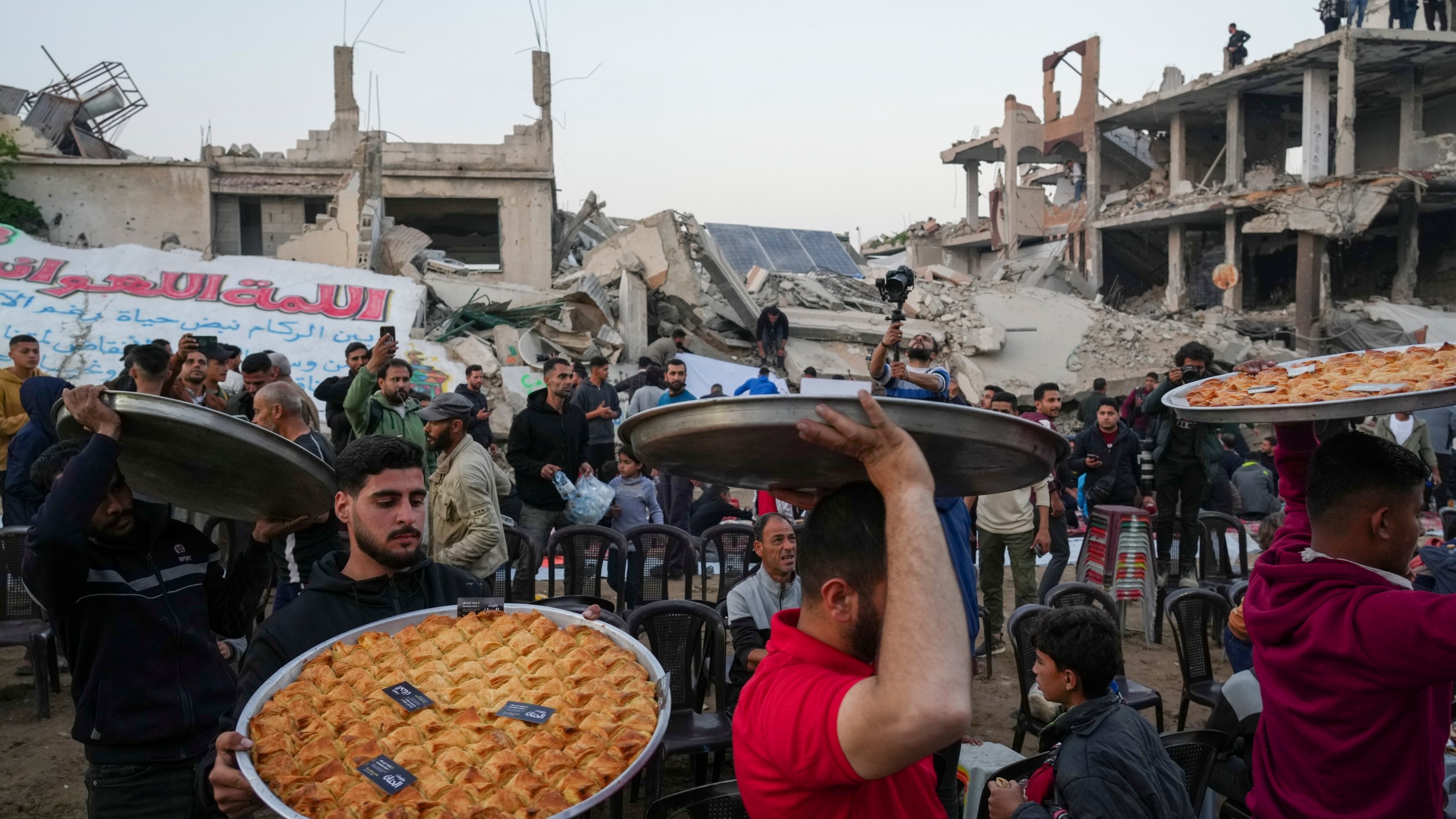 Traditional sweets are served at the tables as residents prepare for Iftar, the fast-breaking meal, during Ramadan in the war-devastated Beit Lahia, northern Gaza Strip, Saturday, March 15, 2025. (AP Photo/Jehad Alshrafi)
