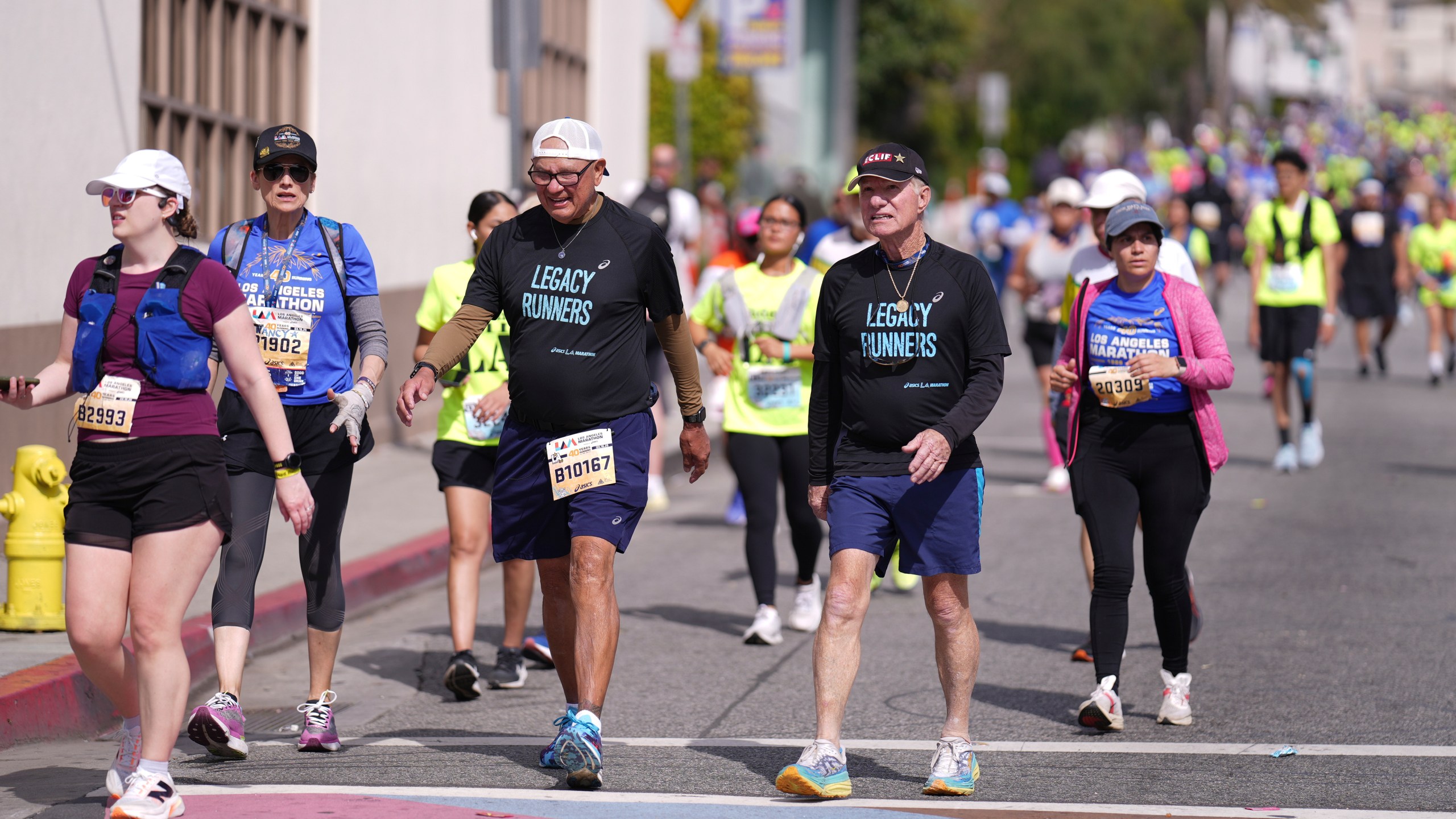 Cliff Housego, center right, and Lou Briones, center left, participate in the LA Marathon before the race Sunday, March 16, 2025, in Los Angeles. (AP Photo/Eric Thayer)