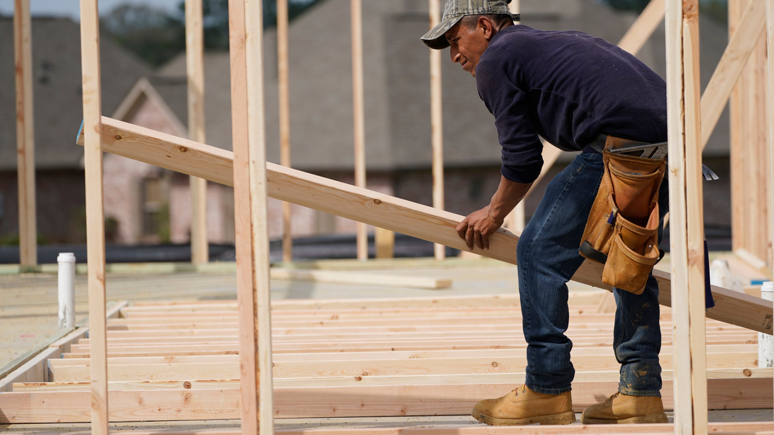 FILE - A carpenter aligns a beam for a wall frame at a new house site in Madison County, Miss., Tuesday, March 16, 2021. (AP Photo/Rogelio V. Solis, File)