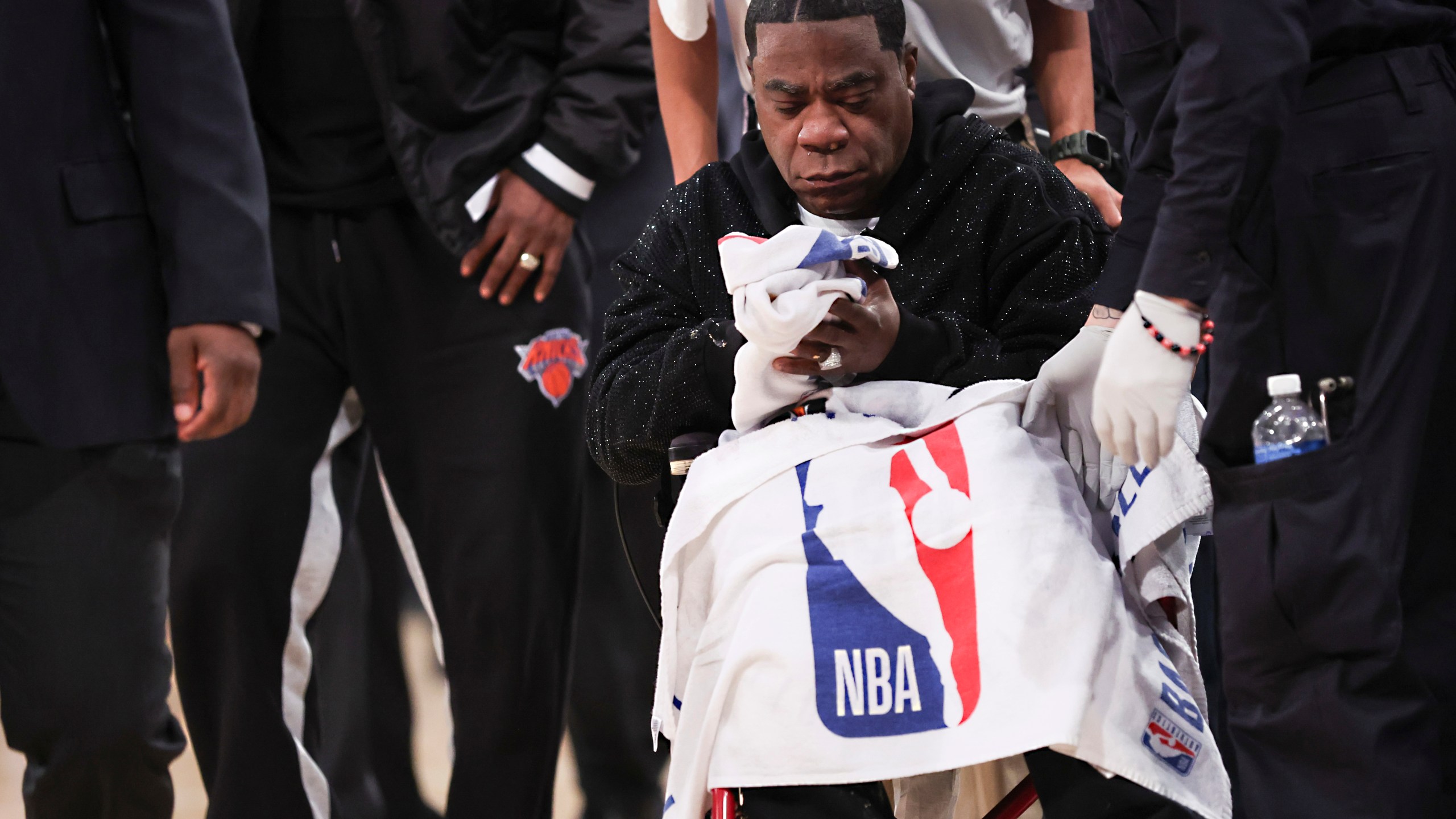 Actor-comedian Tracy Morgan sits in a wheelchair as he is tended to after he became ill and had to leave an NBA basketball game between the New York Knicks and Miami Heat in a wheelchair due to illness, Monday, March 17, 2025, in New York. (AP Photo/Heather Khalifa)