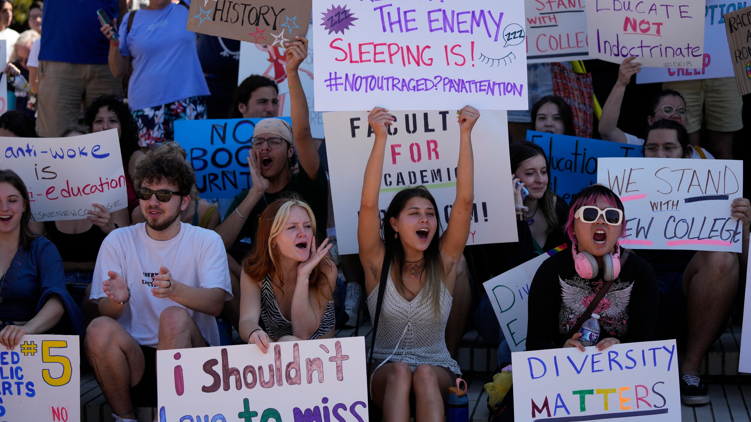 FILE - New College of Florida students and supporters protest ahead of a meeting by the college's board of trustees, Feb. 28, 2023, in Sarasota, Fla. The conservative-dominated board of trustees of Florida's public honors college was meeting to take up a measure making wholesale changes in the school's diversity, equity and inclusion programs and offices. (AP Photo/Rebecca Blackwell, File)