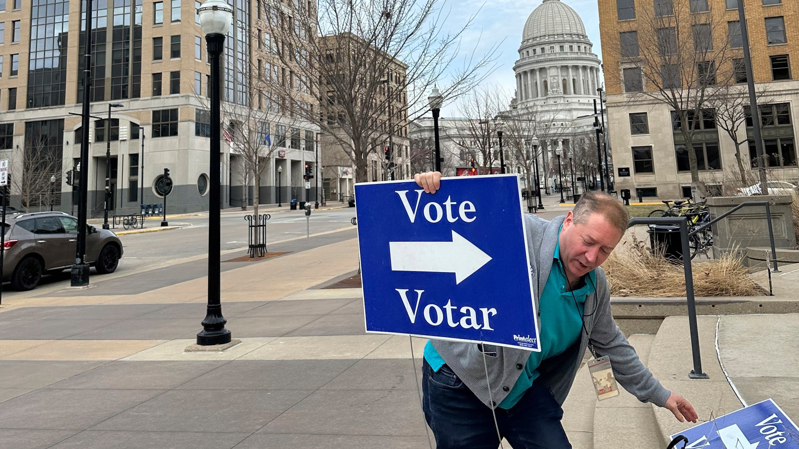 Election worker Mike Quieto with the city of Madison puts out voting signs near the state Capitol ahead of polls opening for the first day of early voting in the race for state Supreme Court on Tuesday, March 18, 2025, in Madison, Wis. (AP Photo/Scott Bauer)