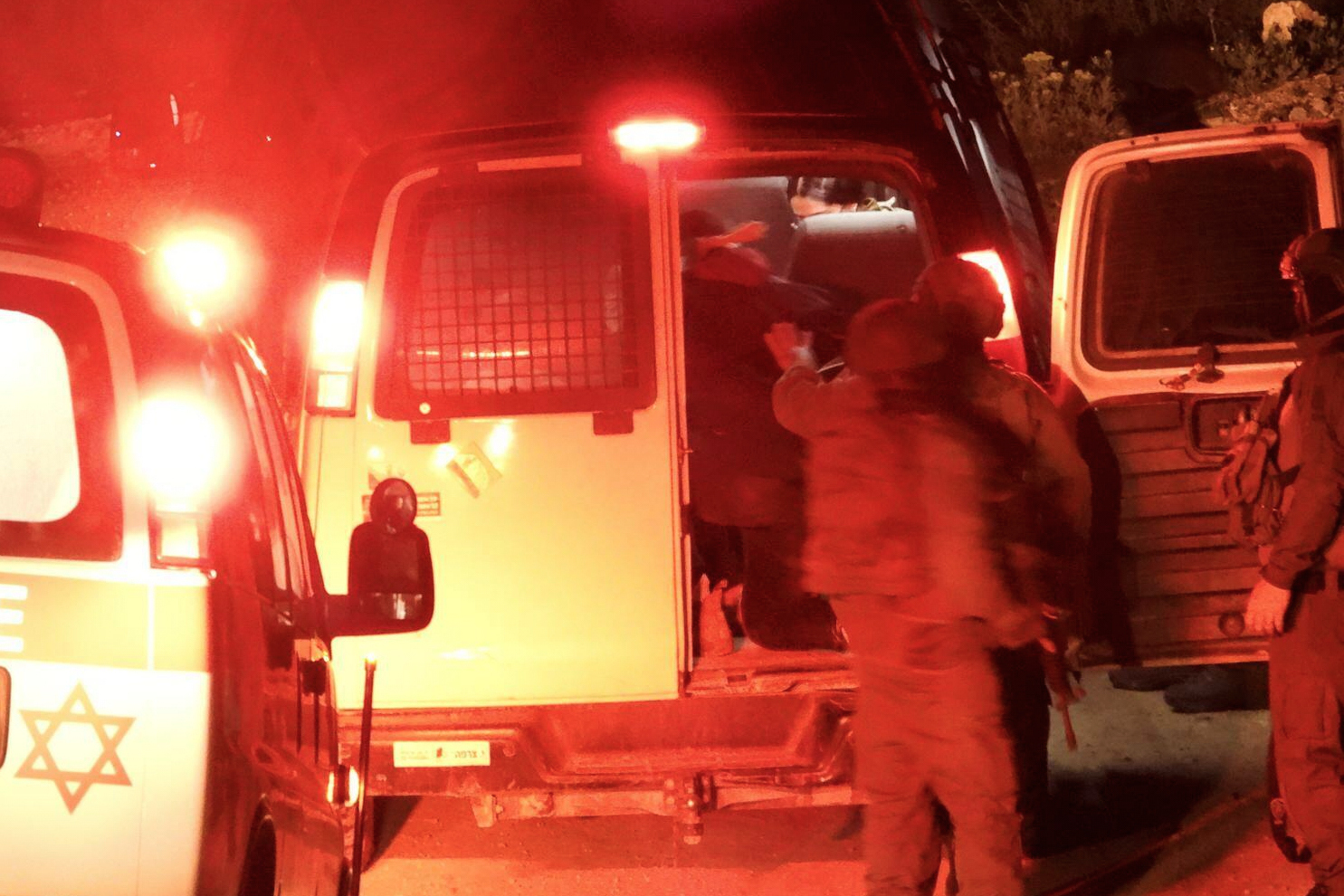 Hamdan Ballal is loaded into the back of a van by the Israeli military