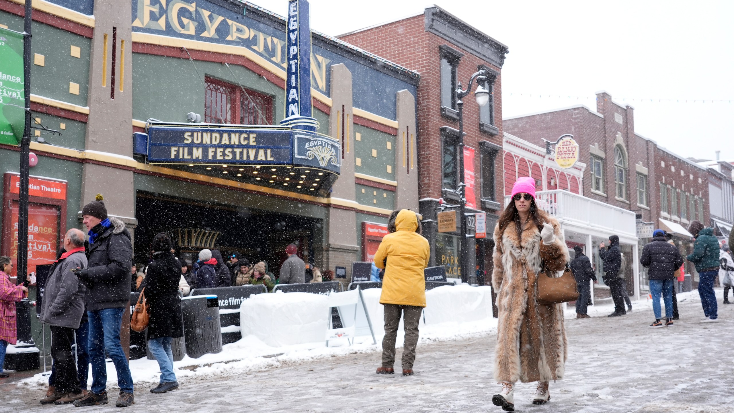 FILE - A Sundance festivalgoer walks past the Egyptian Theatre during the Sundance Film Festival on Jan. 25, 2025, in Park City, Utah. (AP Photo/Chris Pizzello, File)