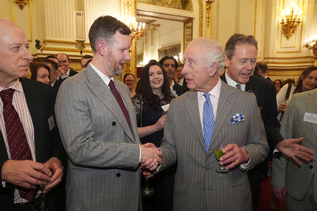 Britain's King Charles III greets a guest during a reception at Buckingham Palace, London, for guests from a wide range of media organisations across the country, Wednesday March 26, 2025. (Aaron Chown, Pool via AP)