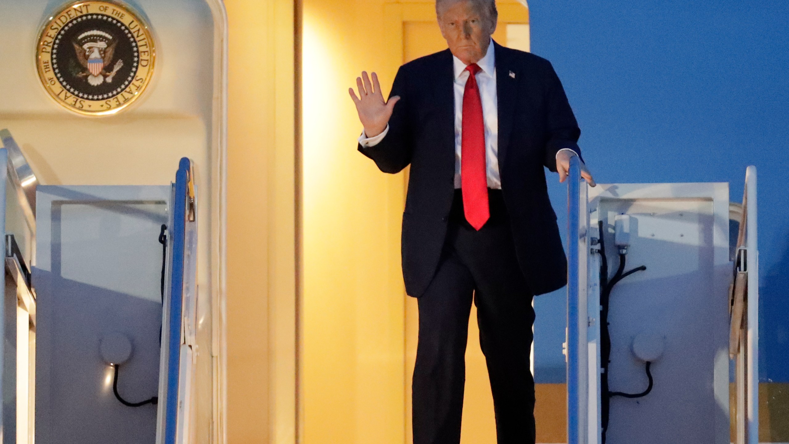 President Donald Trump waves as he walks down the stairs of Air Force One upon his arrival at Joint Base Andrews, Md., Sunday, March 30, 2025. (AP Photo/Luis M. Alvarez)