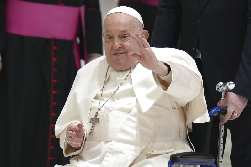 Pope Francis waves from a chair