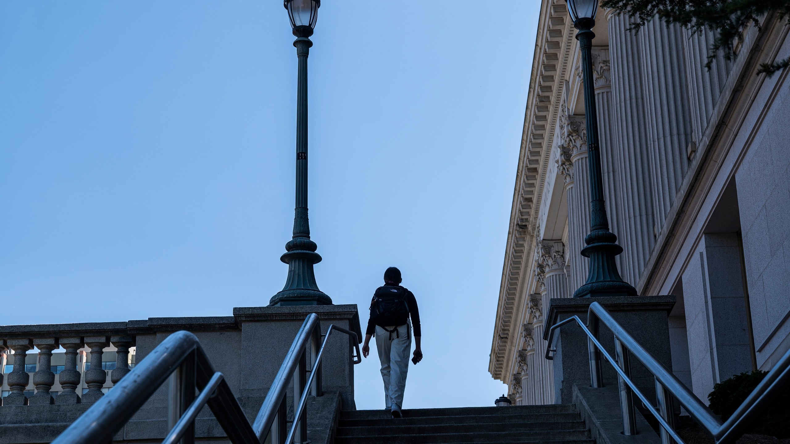 A student walks up steps on college campus