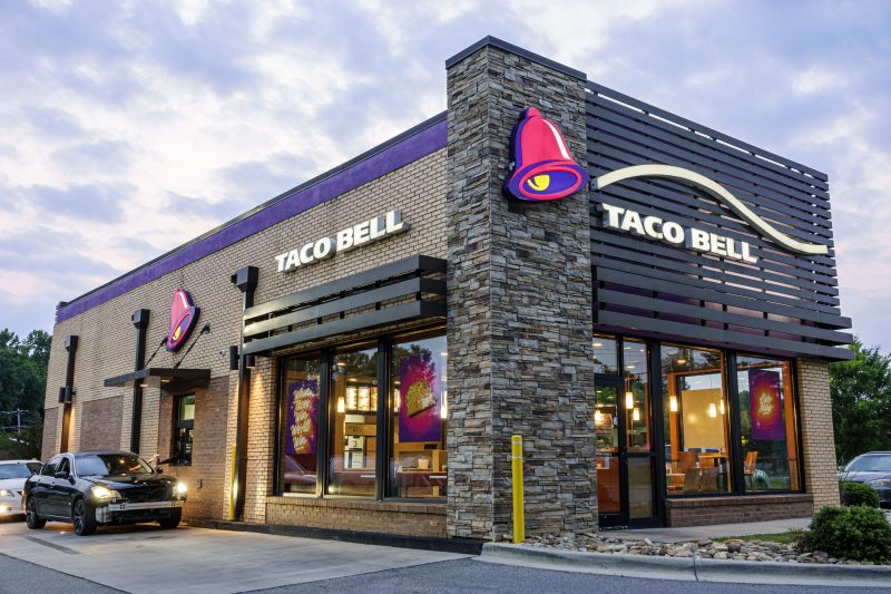 Taco Bell Mexican fast food restaurant and drive-thru at dusk.