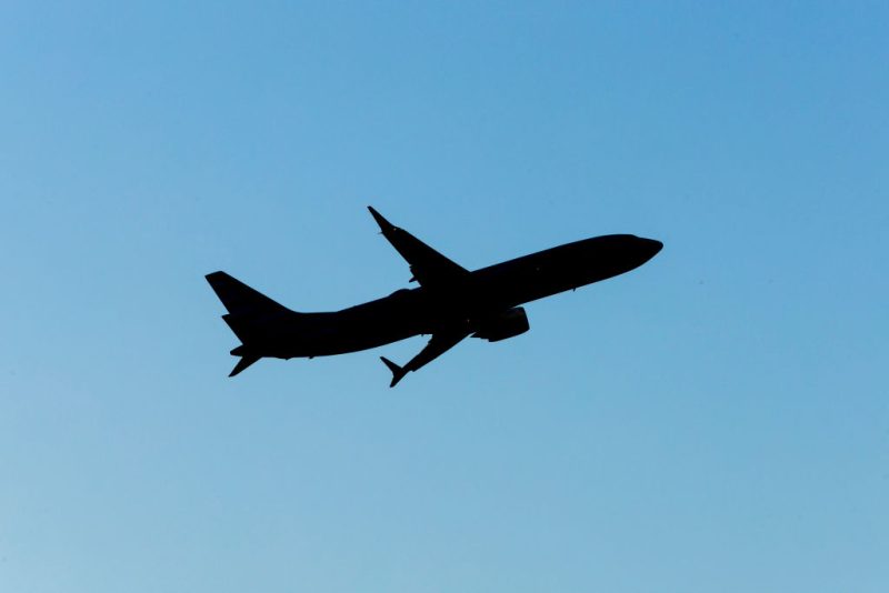 Silhouette of an airplane in a blue sky