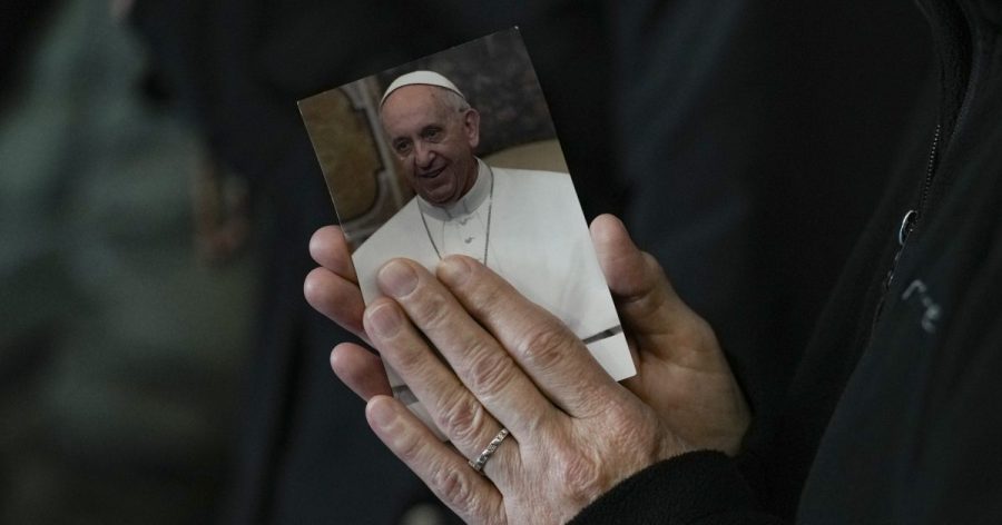 A woman's hands holding a photo of Francis