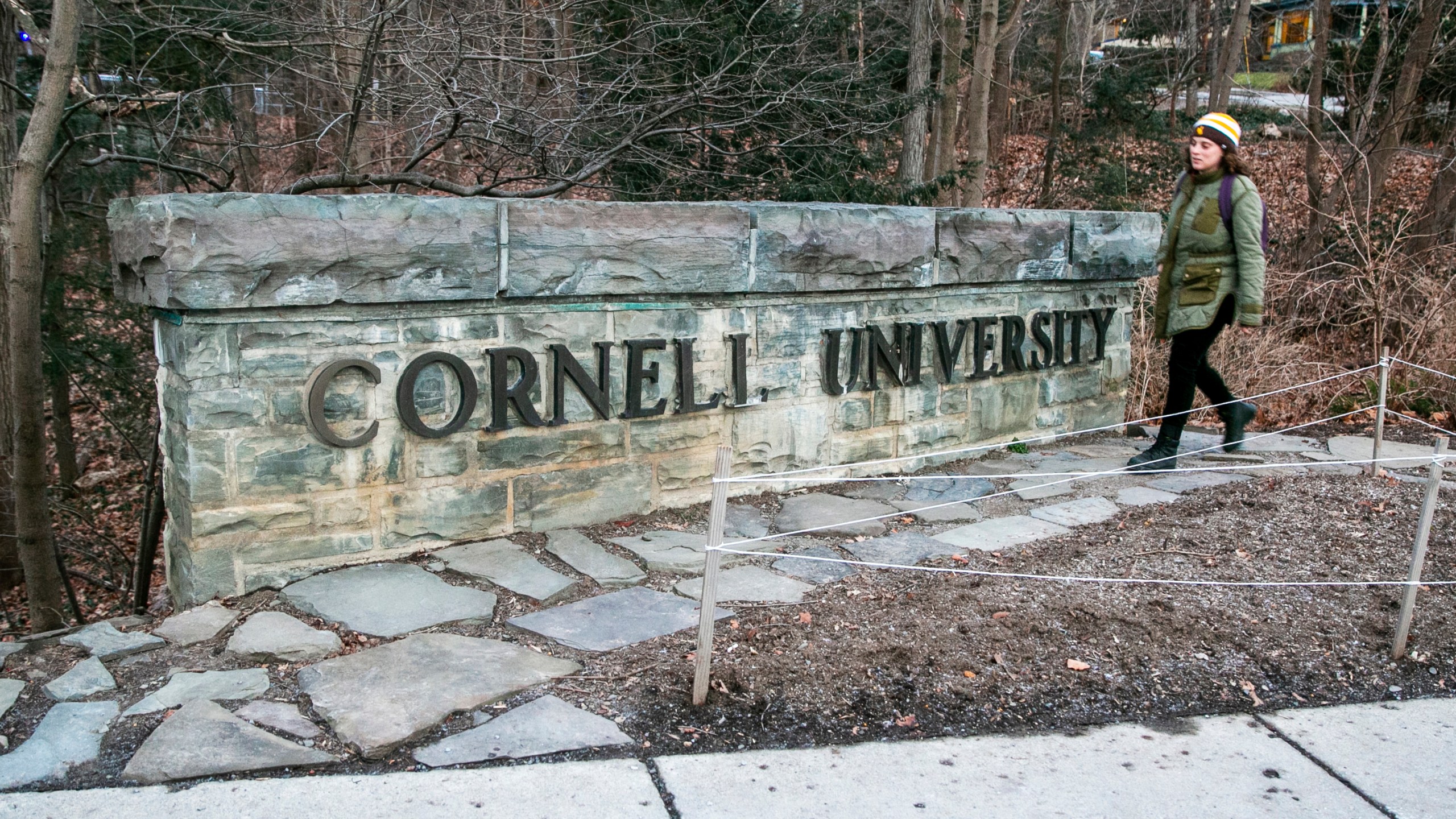 A woman walks by a Cornell University sign on the Ivy League school's campus in Ithaca, New York, on Friday, Jan. 14, 2022. (AP Photo/Ted Shaffrey, File)