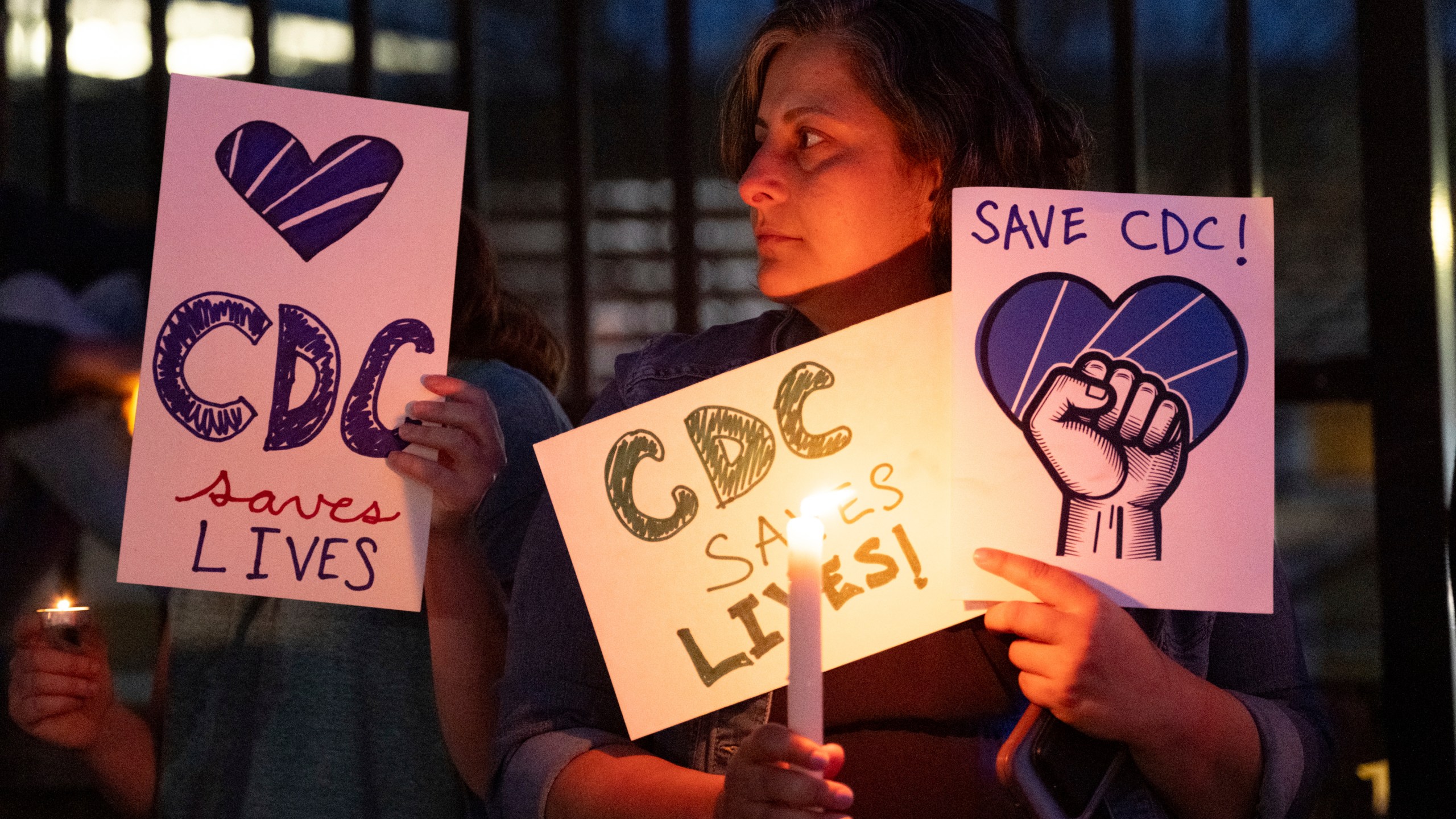People gather for a candlelight vigil in support of the Centers for Disease Control and Prevention in front of its headquarters in Atlanta, Friday, March 28, 2025. (AP Photo/Ben Gray)