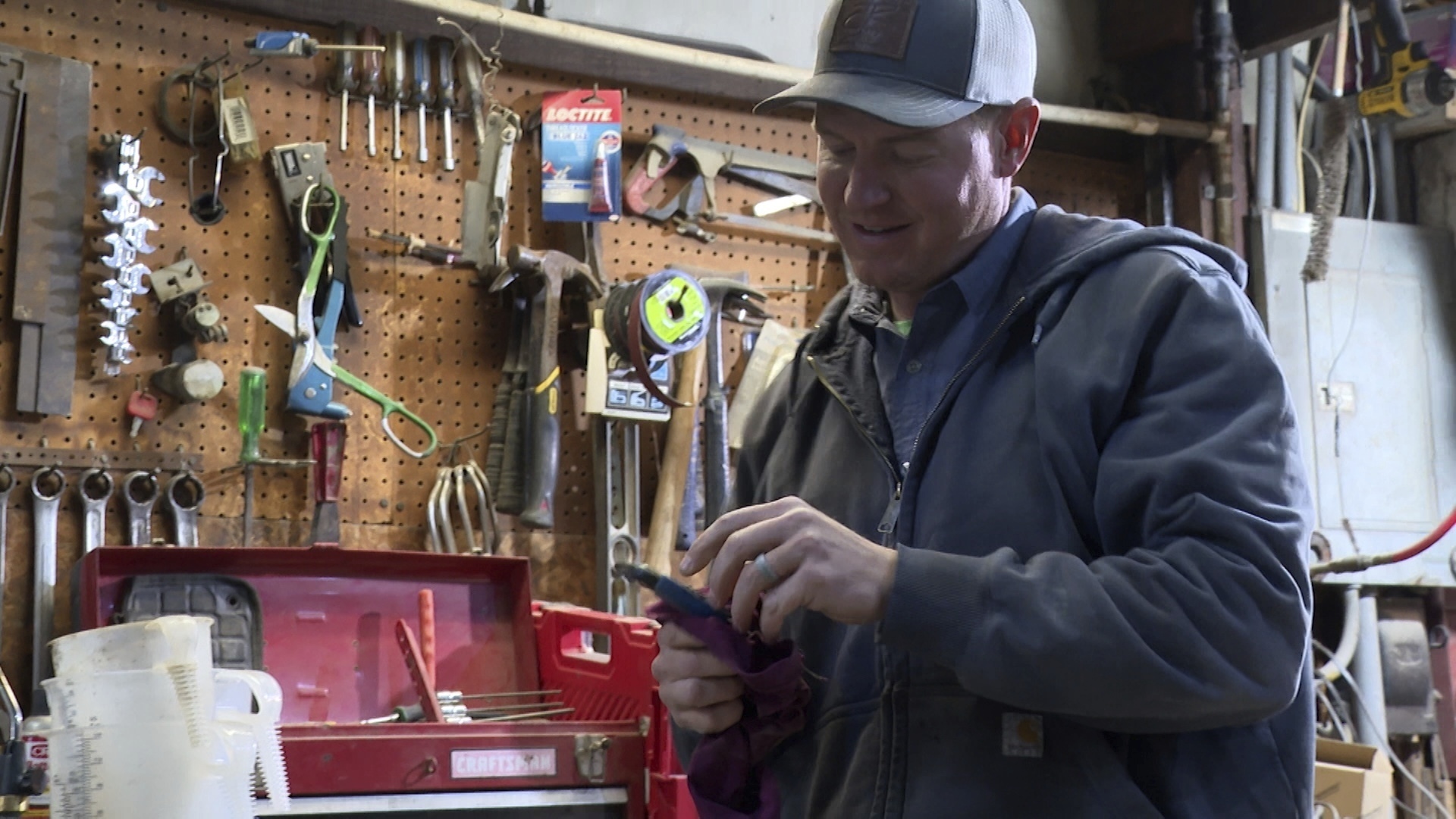 Bryant Kagay holds a tool in the workshop of the farm he co-owns with his father and grandfather in Amity, Missouri, Friday, April 4, 2025. (AP Photo/Nick Ingram)