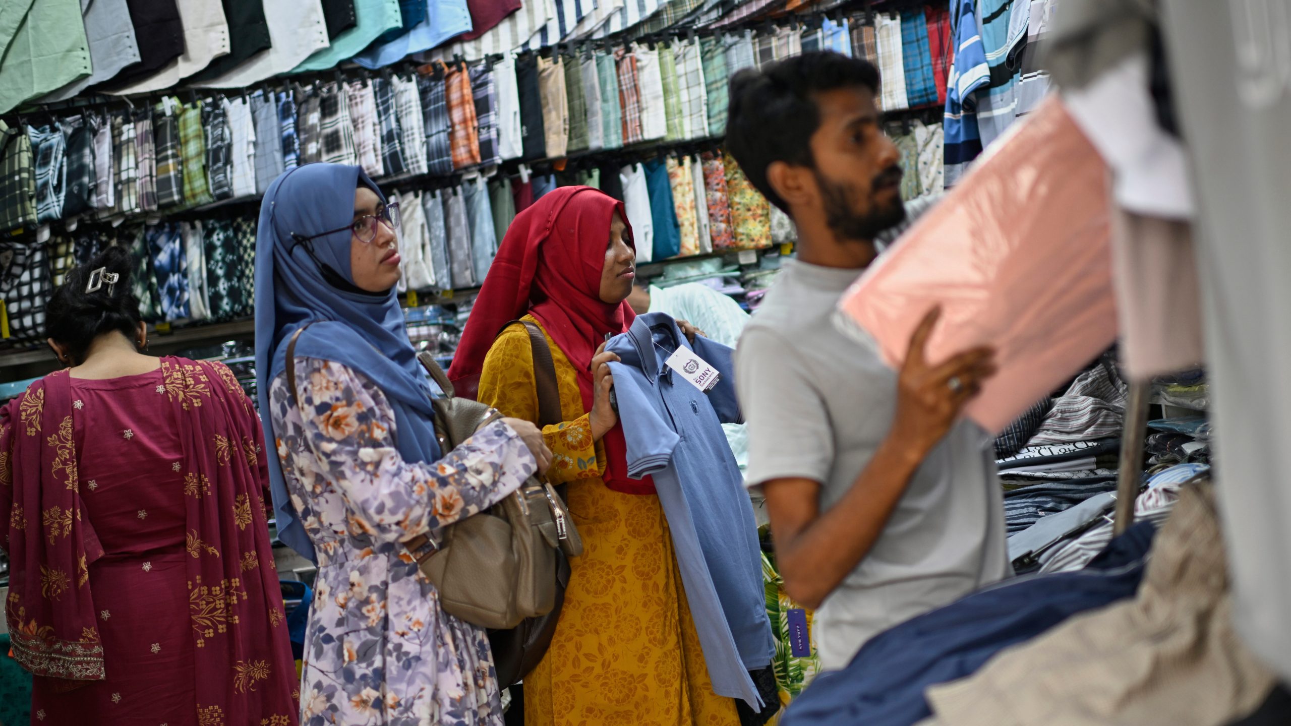 Women shop for clothes at a garments market in Dhaka, Bangladesh, Thursday, April 3, 2025. (AP Photo/Mahmud Hossain Opu)