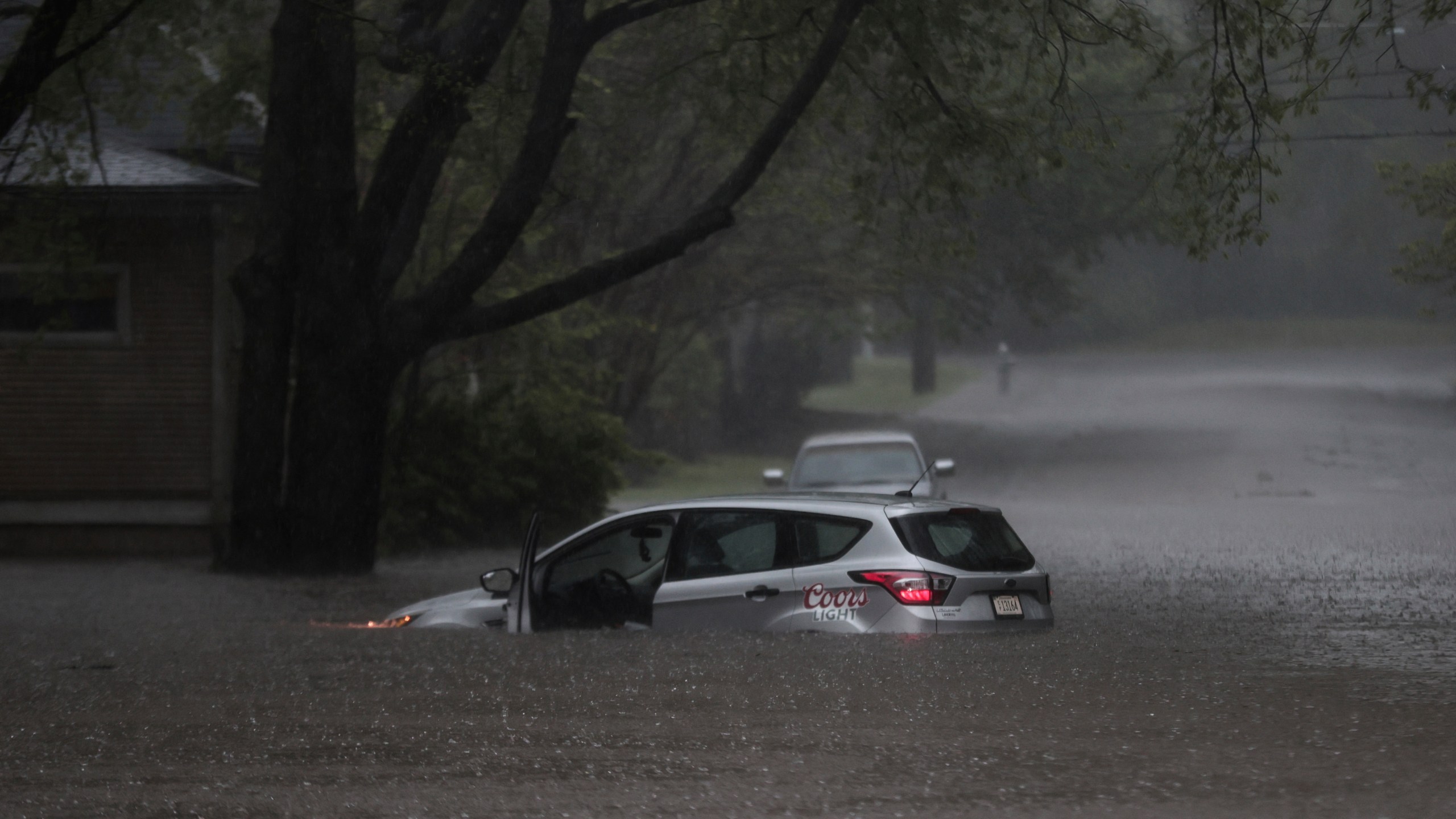 A car is stuck in floodwaters near the corner of Cowden Street and Tanglewood Avenue as heavy rain falls, Saturday, April 5, 2025, in Memphis, Tenn. (Patrick Lantrip/Daily Memphian via AP)