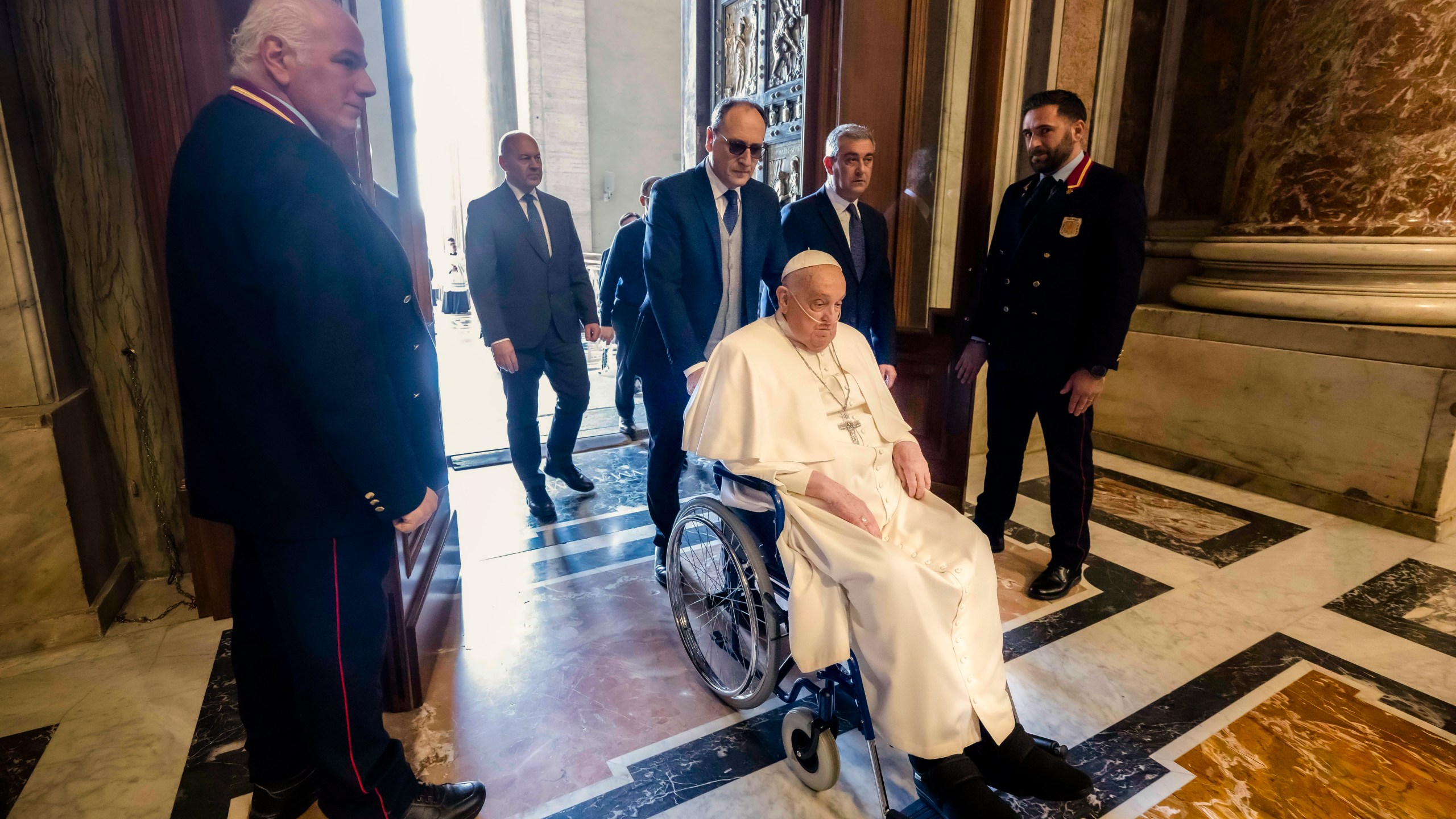 In this image released by Vatican Media, Pope Francis passe through the Holy door in a wheelchair at the end of a mass in St. Peter's Square at The Vatican, Sunday, April 6, 2025, part of the Jubilee of the sick and the health workers. (Vatican Media via AP, HO)