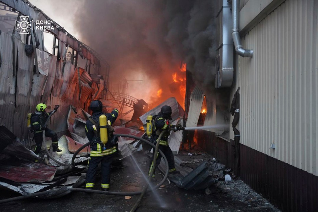 In this photo provided by the Ukrainian Emergency Service, emergency services personnel work to extinguish a fire following a Russian missile attack in Kyiv, Ukraine, Sunday, April 6, 2025. (Ukrainian Emergency Service via AP)