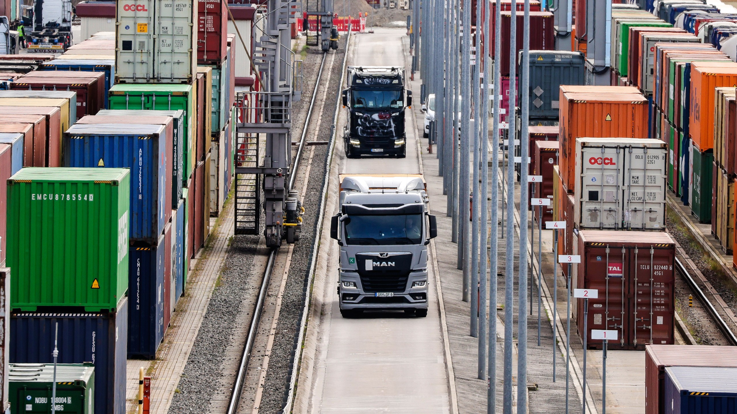 Trucks with containers drive through a logistic-terminal in Leipzig, Germany, Monday, April 7, 2025. (Jan Woitas/dpa via AP)