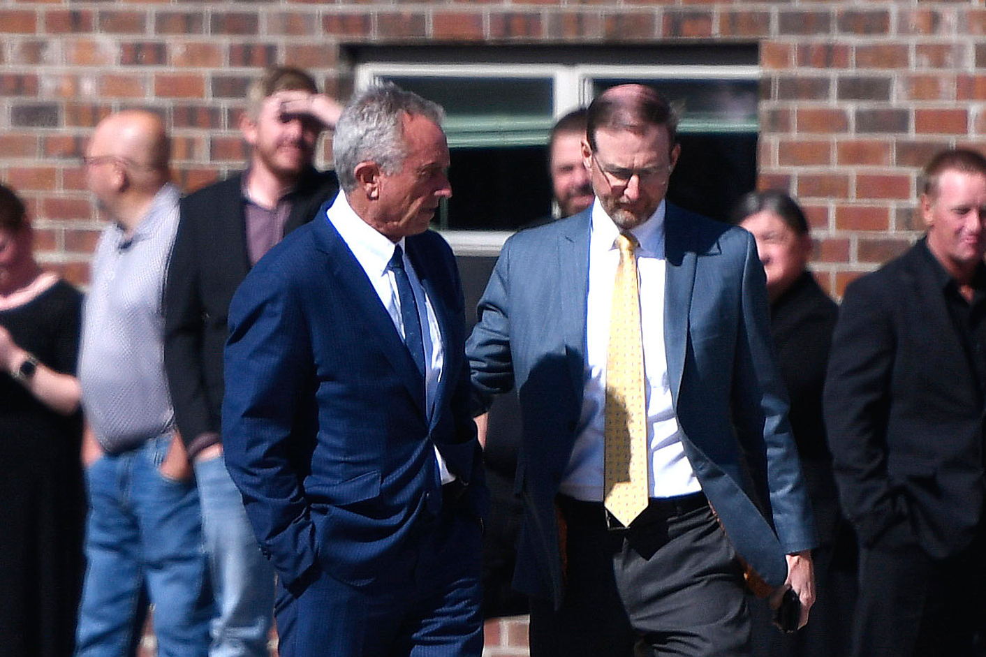 Health and Human Services Secretary Robert F. Kennedy Jr., left, arrives at Reinlander Mennonite Church after a second measles death, Sunday, April 6, 2025, in Seminole, Texas. (AP Photo/Annie Rice)