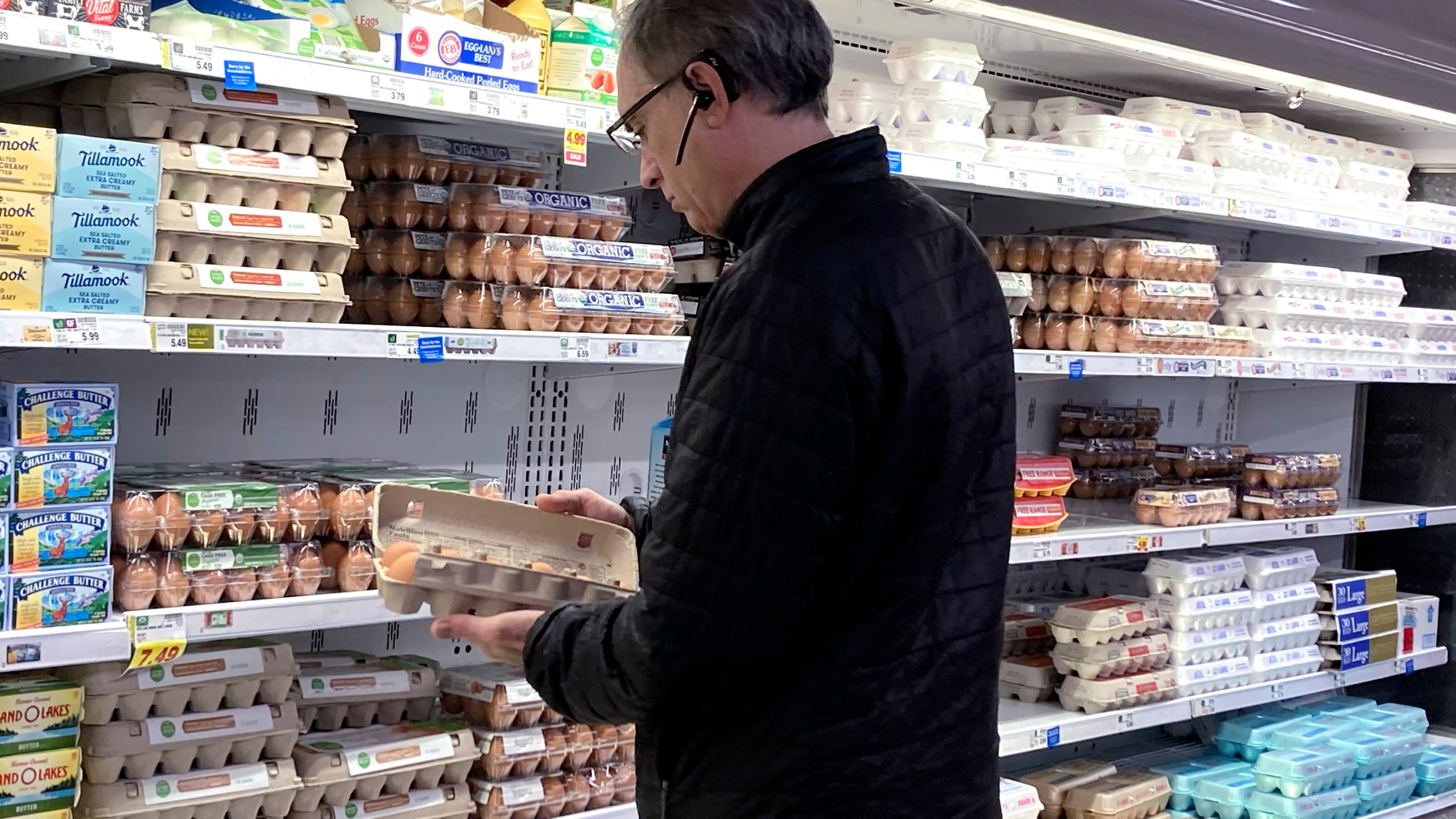 A shopper checks eggs at a grocery store