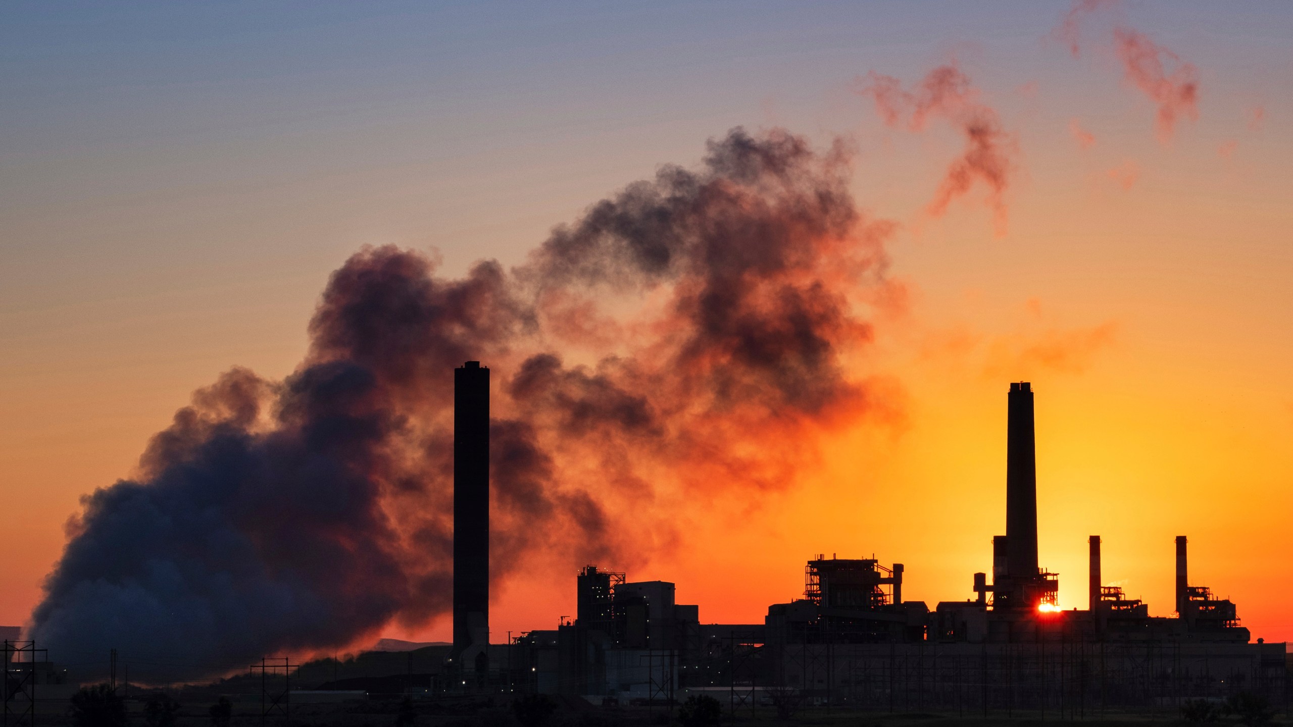 FILE - The Dave Johnson coal-fired power plant is silhouetted against the morning sun in Glenrock, Wyo., July 27, 2018 (AP Photo/J. David Ake, File)