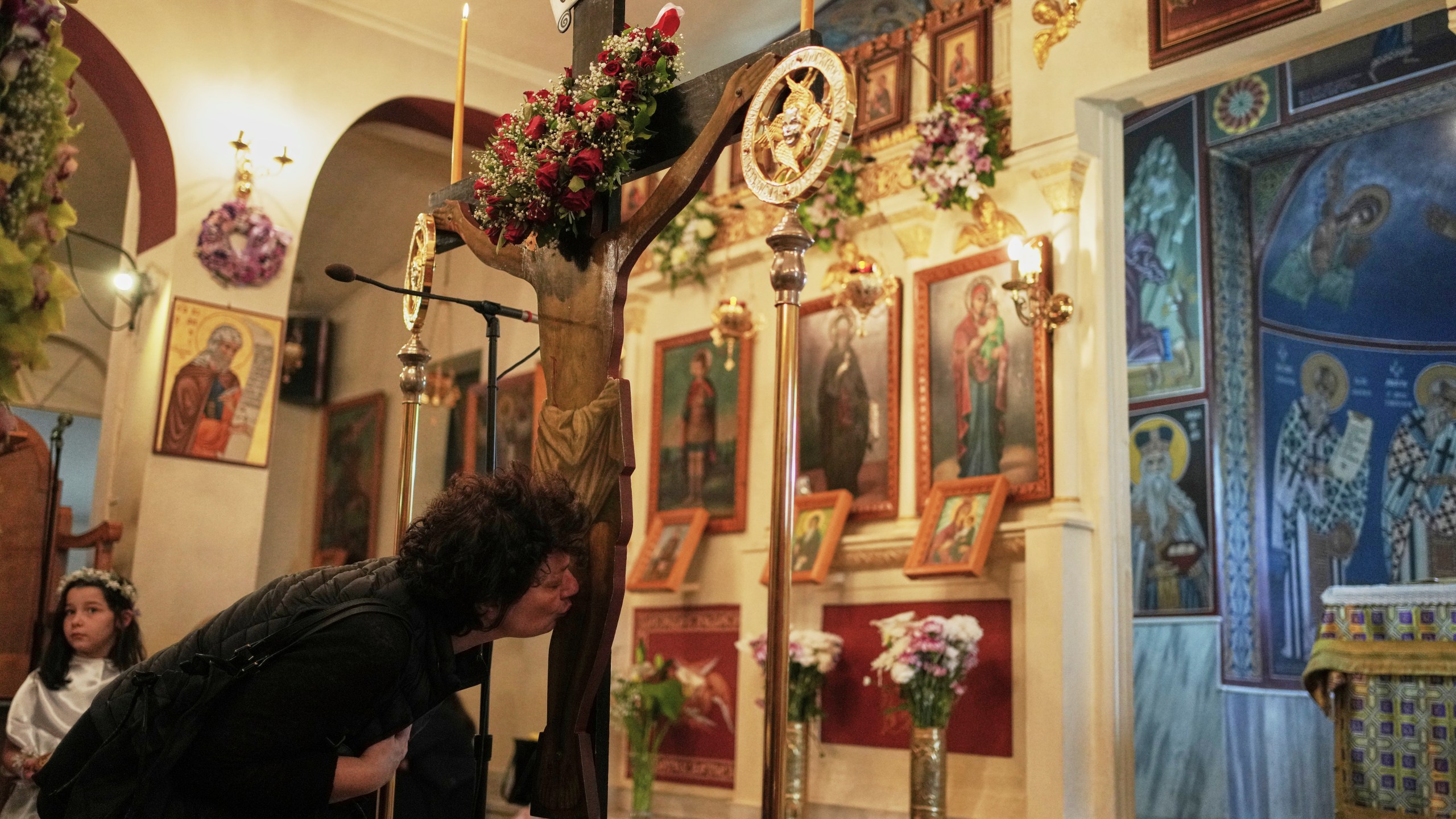 An Orthodox faithful kisses a crucifix during a Good Friday reenactment of Deposition of Jesus Christ, at Agios Antonios church in the northern suburb of Chalandri, in Athens, Greece, Friday, April 18, 2025. (AP Photo/Thanassis Stavrakis)