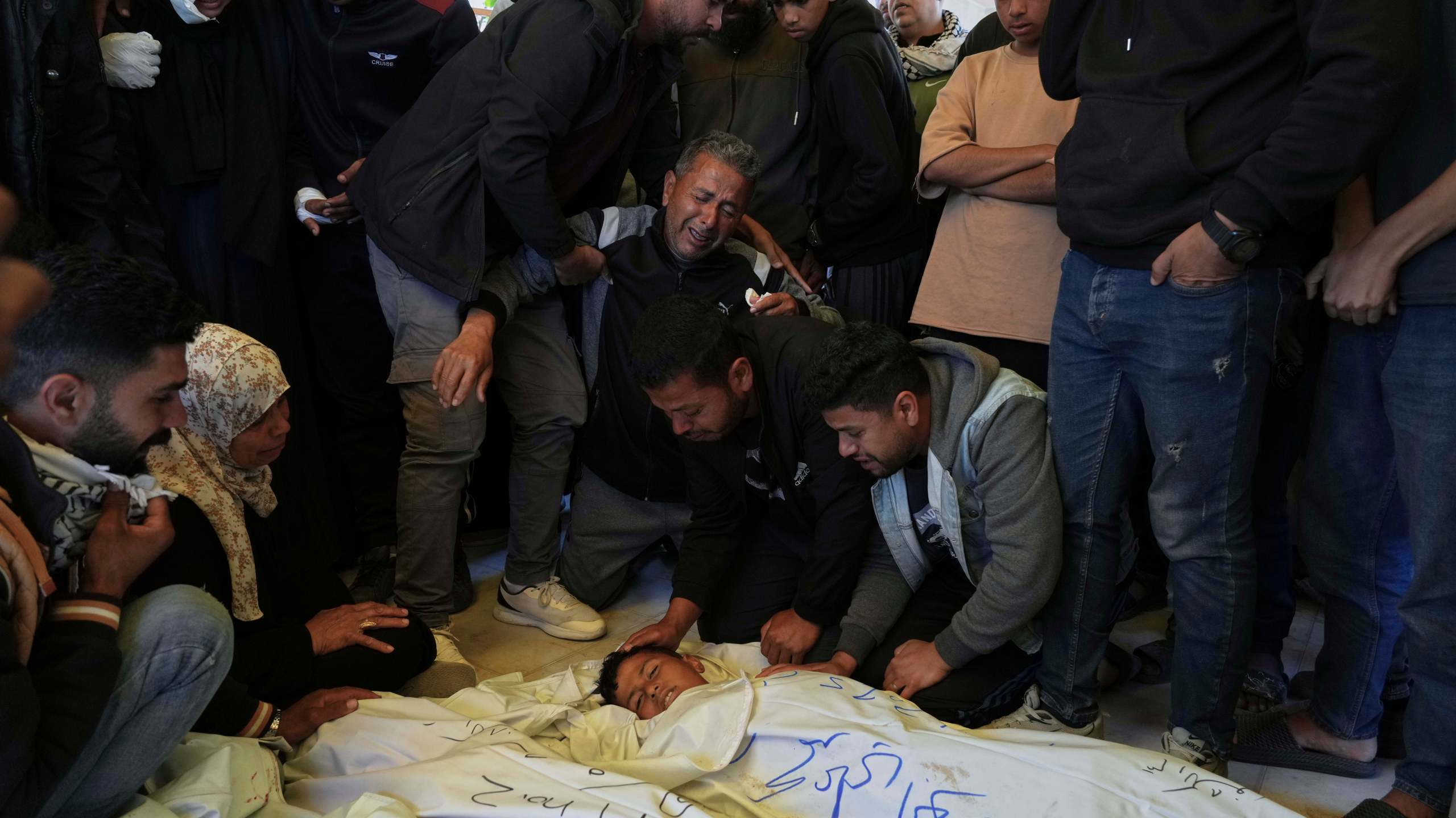 Mourners grieve over the body of Palestinian child Mohammad Abu Nada, killed in an Israeli army airstrike, during his funeral in Khan Younis, southern Gaza Strip, on Saturday, April 19, 2025. (AP Photo/Abdel Kareem Hana)