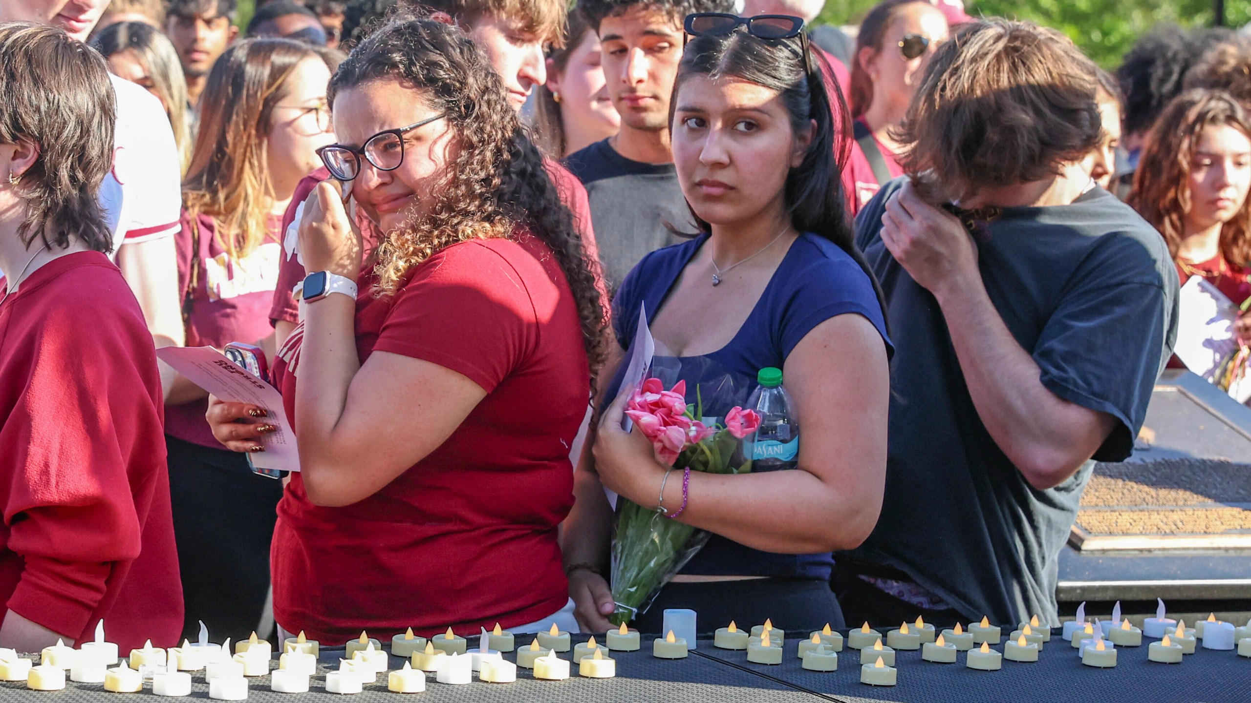 The day after an active shooter on campus Florida State students place electronic candles on a platform during a vigil on campus at Langford Green, Tallahassee, Fla., Friday, April 18, 2025. (AP Photo/Gary McCullough)