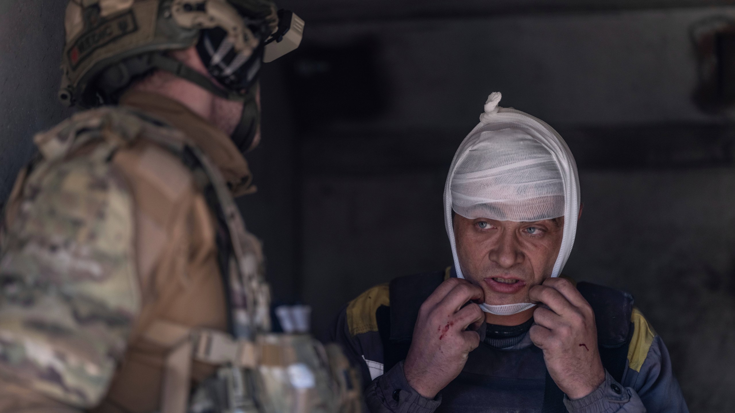 In this photo provided by Ukraine's 93rd Kholodnyi Yar Separate Mechanized Brigade press service, a police medic gives first aid to an electrician who was injured by a guided aerial bomb while repairing energy equipment in Kostyantynivka, the site of heavy battles with Russian troops, in the Donetsk region, Ukraine, Saturday, April 19, 2025. (Iryna Rybakova/Ukraine's 93rd Mechanized Brigade via AP)