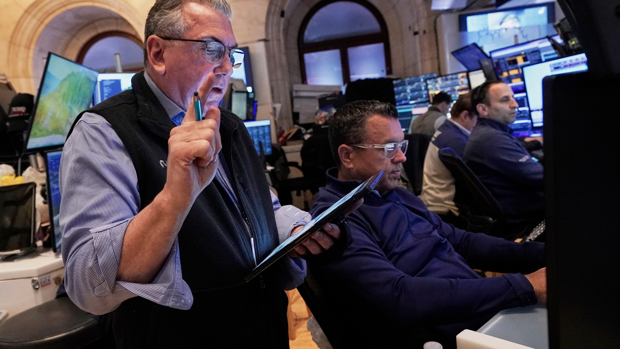 Trader John Bishop, left, works with colleagues on the floor of the New York Stock Exchange, Monday, April 21, 2025. (AP Photo/Richard Drew)
