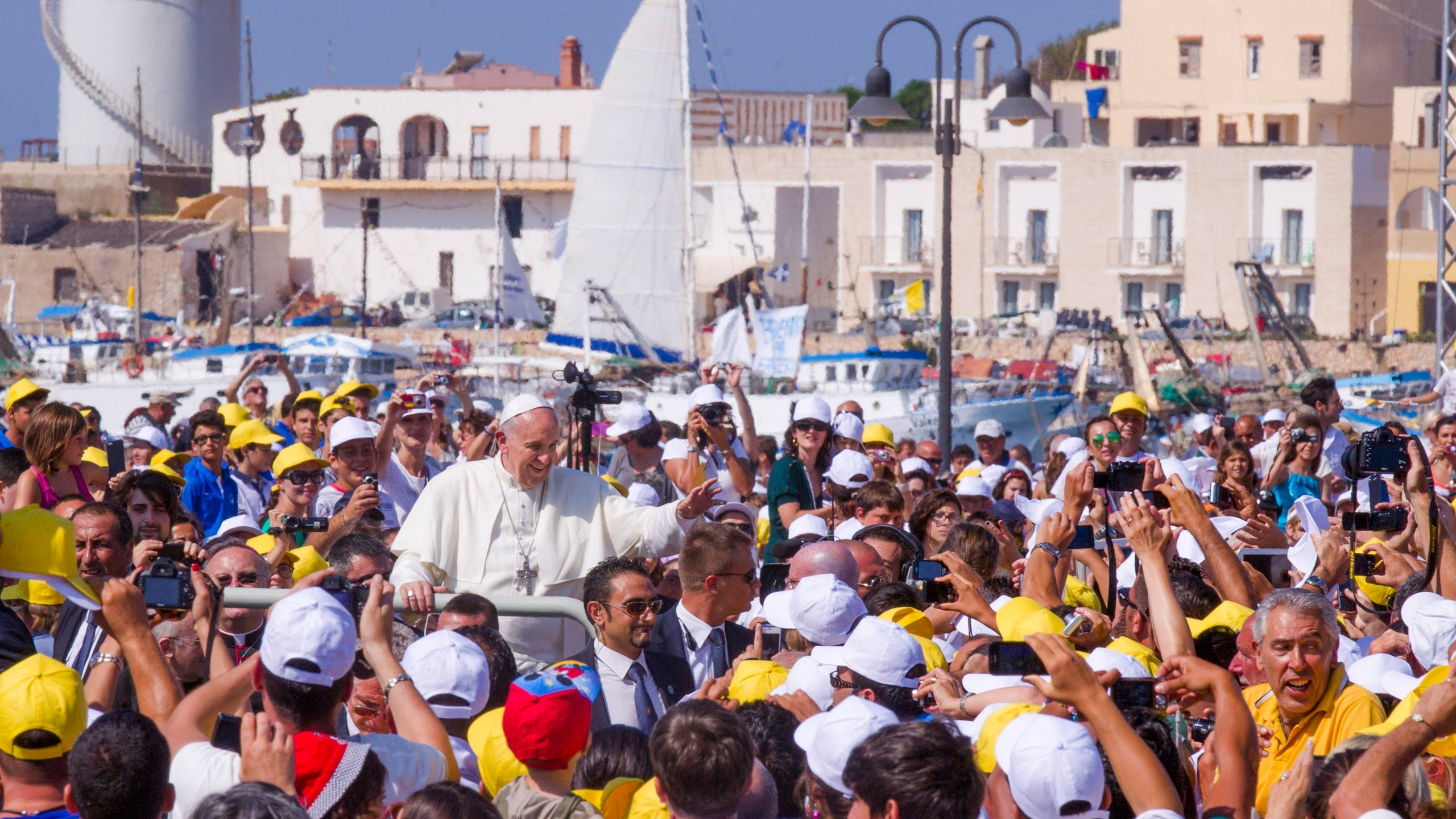 FILE - Pope Francis waves to a cheering crowd during his visit to the island of Lampedusa, Sicily, in southern Italy, July 8, 2013. (AP Photo/Alessandra Tarantino, File)