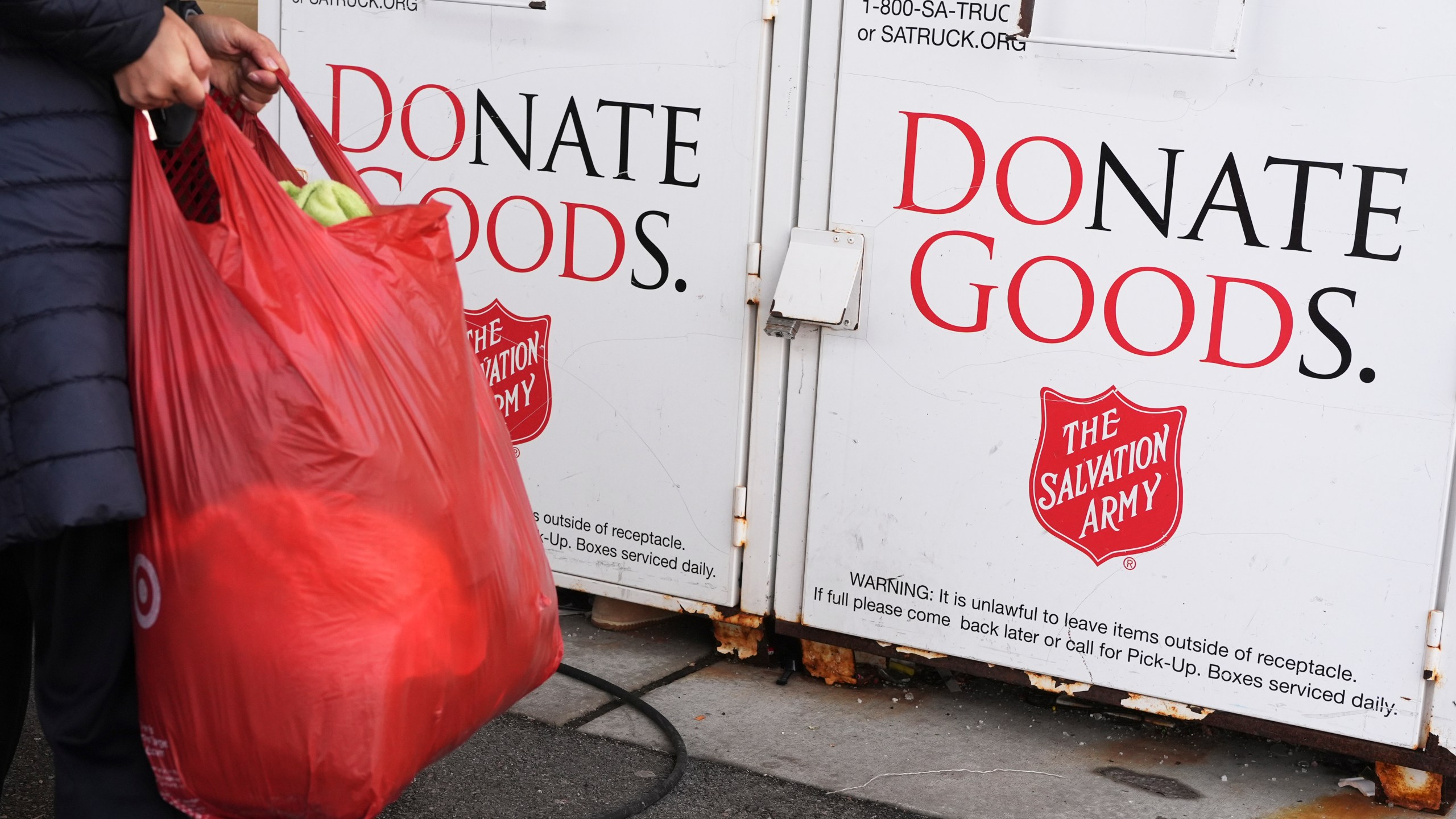 FILE - A woman carries a bag to donation center of the Salvation Army in Glenview, Ill., Thursday, Jan. 11, 2024. (AP Photo/Nam Y. Huh, File)