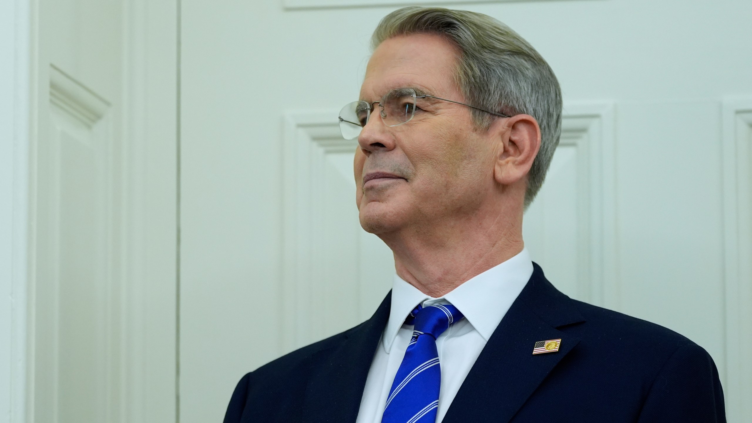 Treasury Secretary Scott Bessent listens as President Donald Trump speaks with reporters as he participates in a ceremonial swearing in of Paul Atkins as chairman of the Securities and Exchange Commission, in the Oval Office of the White House, Tuesday, April 22, 2025, in Washington. (AP Photo/Alex Brandon)