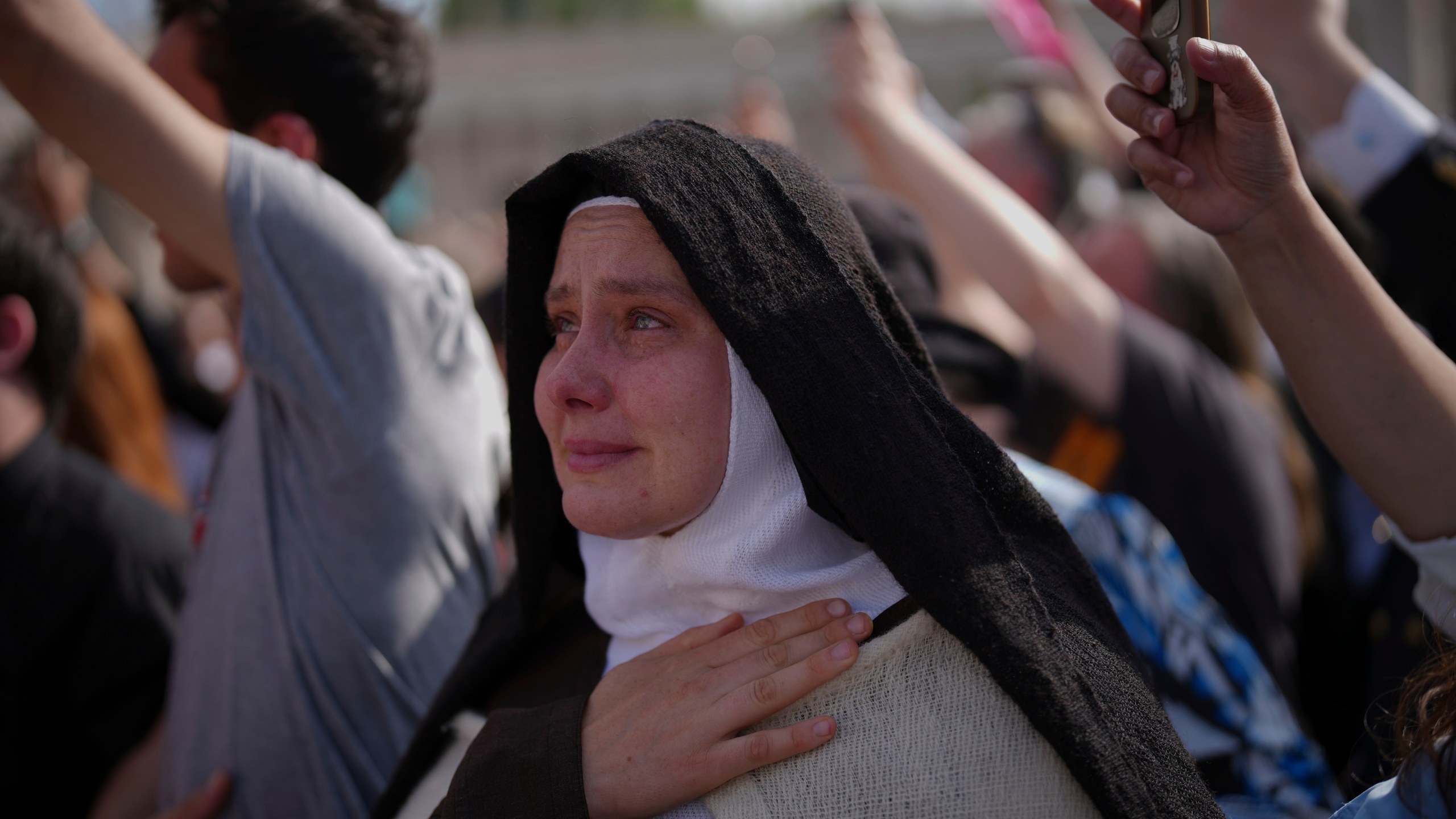 A nun cries as the body of Pope Francis is carried into St. Peter's Basilica at the Vatican, Wednesday, April 23, 2025, where he will lie in state for three days. (AP Photo/Emilio Morenatti)