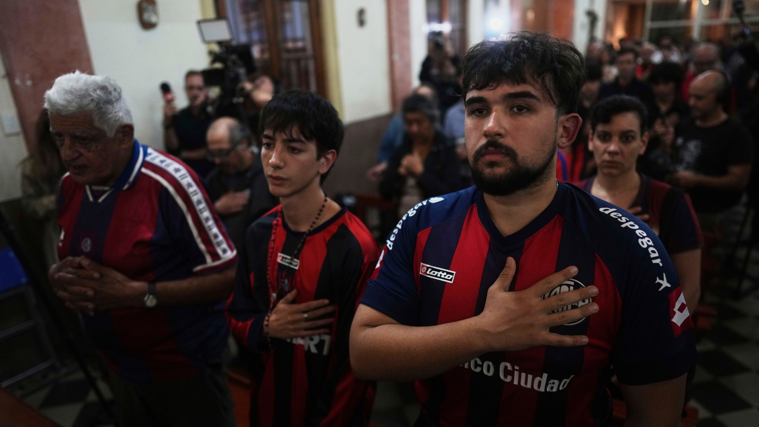 Fans of San Lorenzo soccer club attend a Mass at San Antonio Parish in honor of the late Pope Francis, a lifelong supporter of the club, in Buenos Aires, Argentina, Wednesday, April 23, 2025. (AP Photo/Natacha Pisarenko)