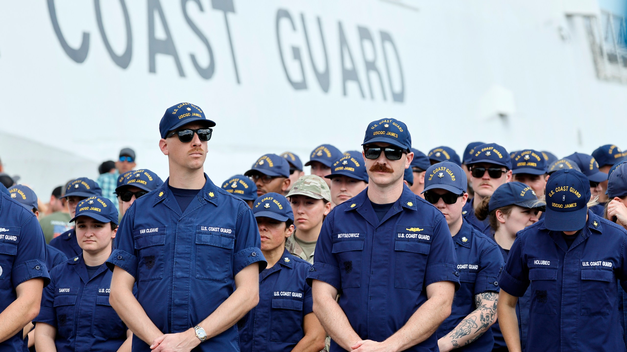 Members of the U.S. Coast Guard await the arrival of U.S. Attorney General Pam Bondi and FBI Director Kash Patel for a news conference at Port Everglades, Fla. (Amy Beth Bennett South Florida Sun-Sentinel via AP)