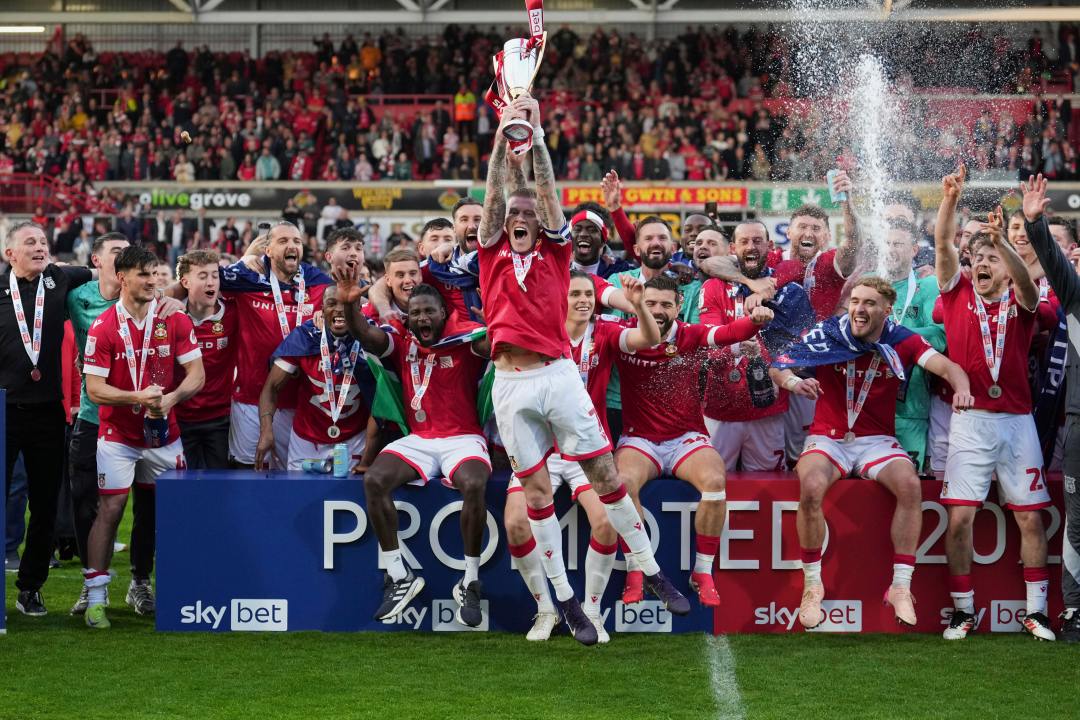 Wrexham's James McClean rises the trophy as they win the English League One soccer match between Wrexham and Charlton Athletic at the Racecourse ground in Wrexham, Wales, Saturday, April 26, 2025. (AP Photo/Jon Super)