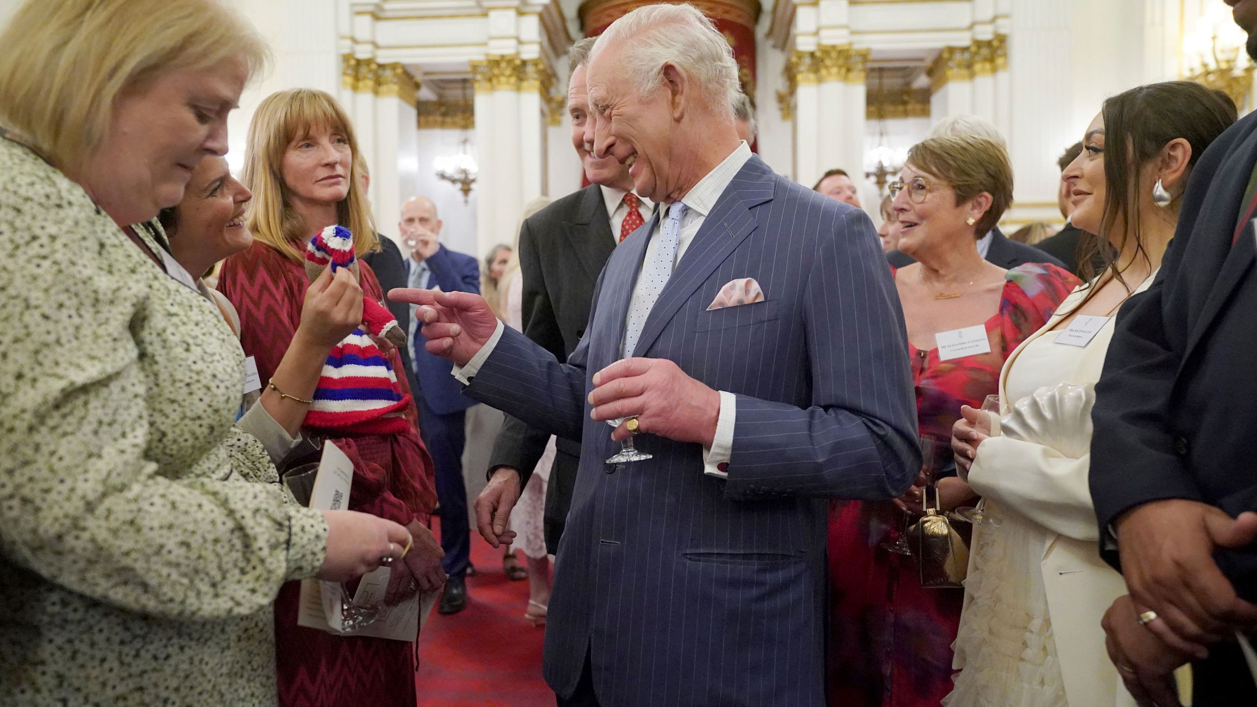 Britain's King Charles III speaks to guests during a reception in Buckingham Palace, London, in celebration of community-based initiatives raising awareness about cancer and supporting those living with cancer, Wednesday April 30, 2025. (Yui Mok/Pool Photo via AP)