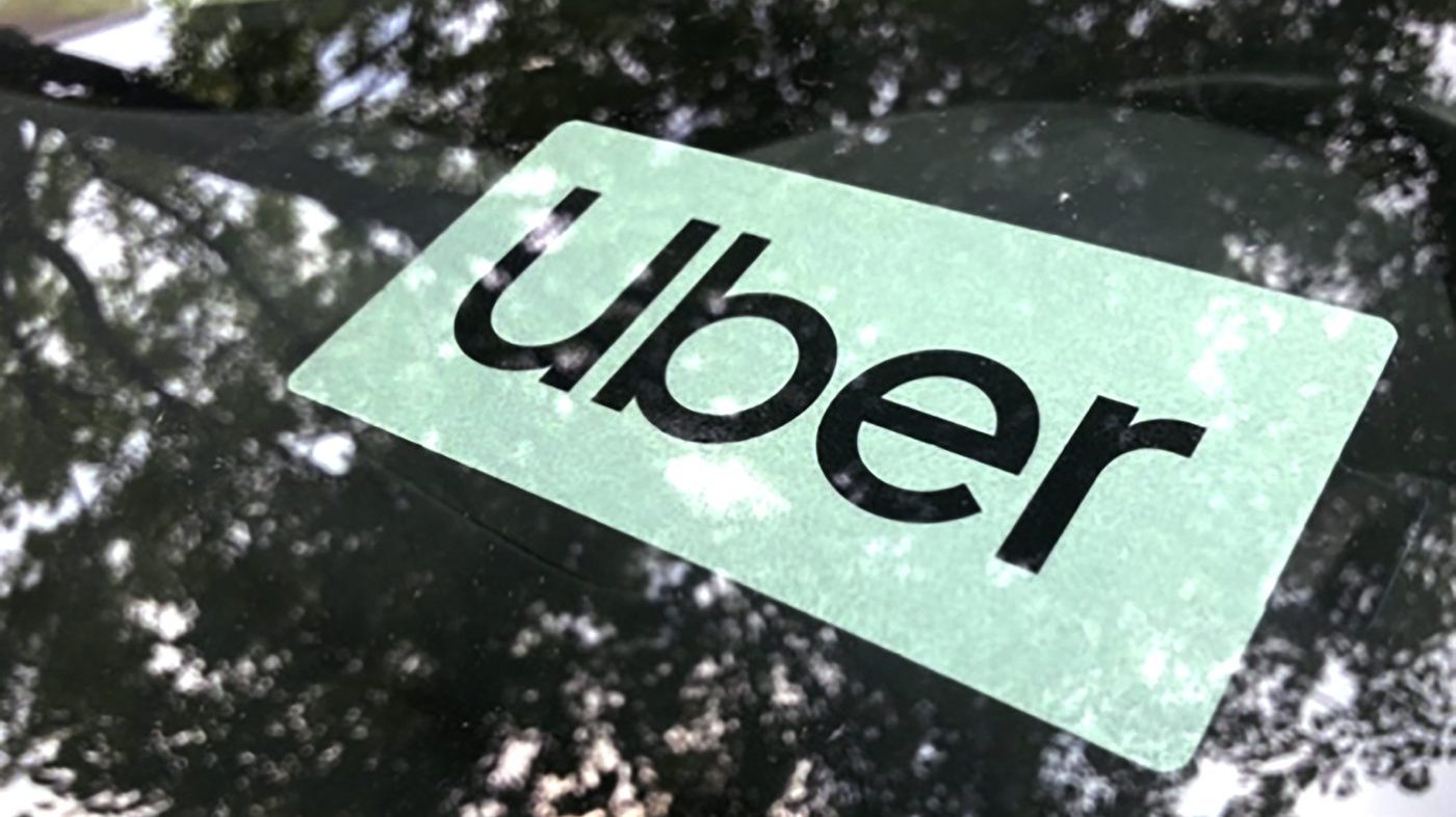 An Uber sign is displayed inside a car in Palatine, Ill