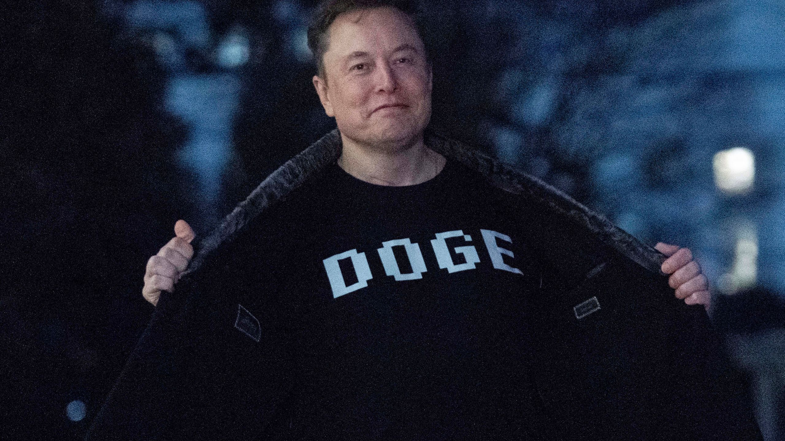 Elon Musk flashes his T-shirt that reads "DOGE"