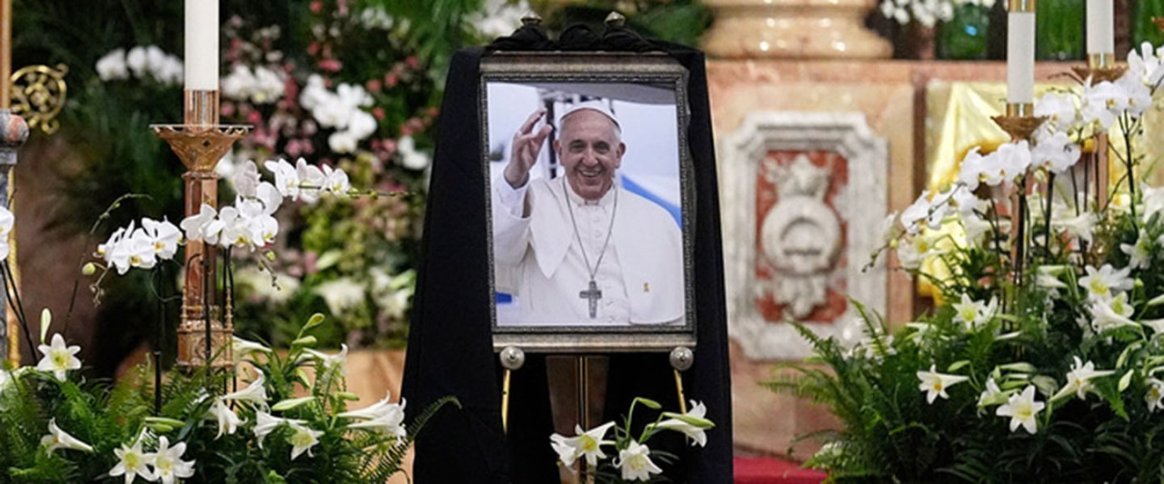 a picture of Pope Francis is displayed inside a Church