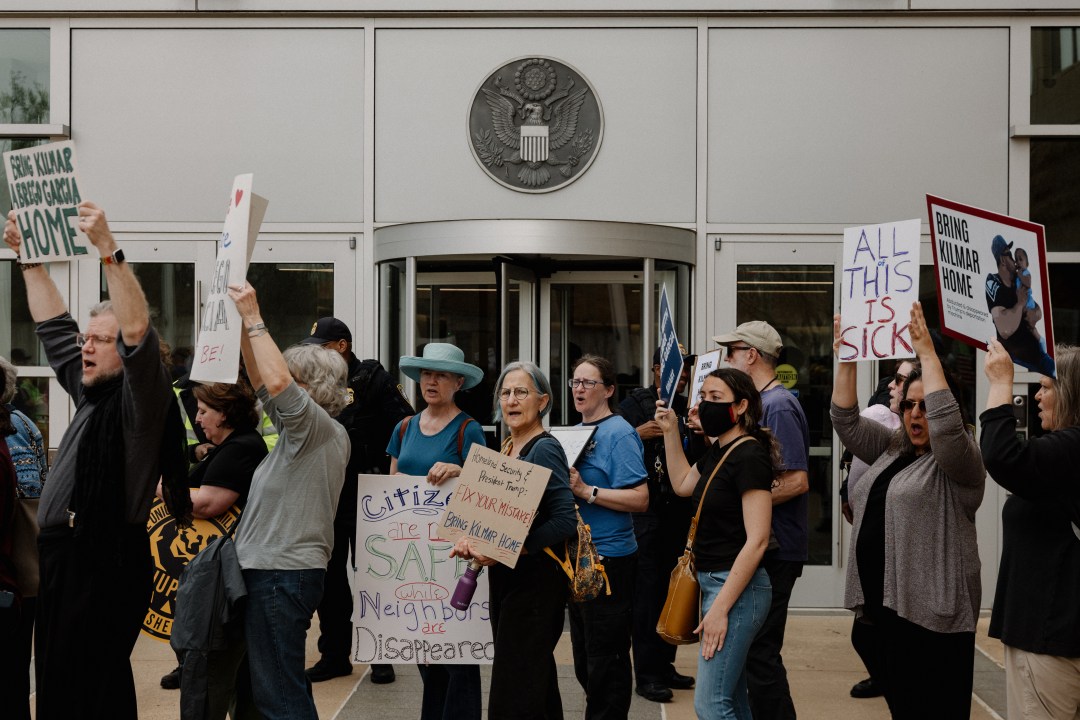 Protesters stand outside a courthouse
