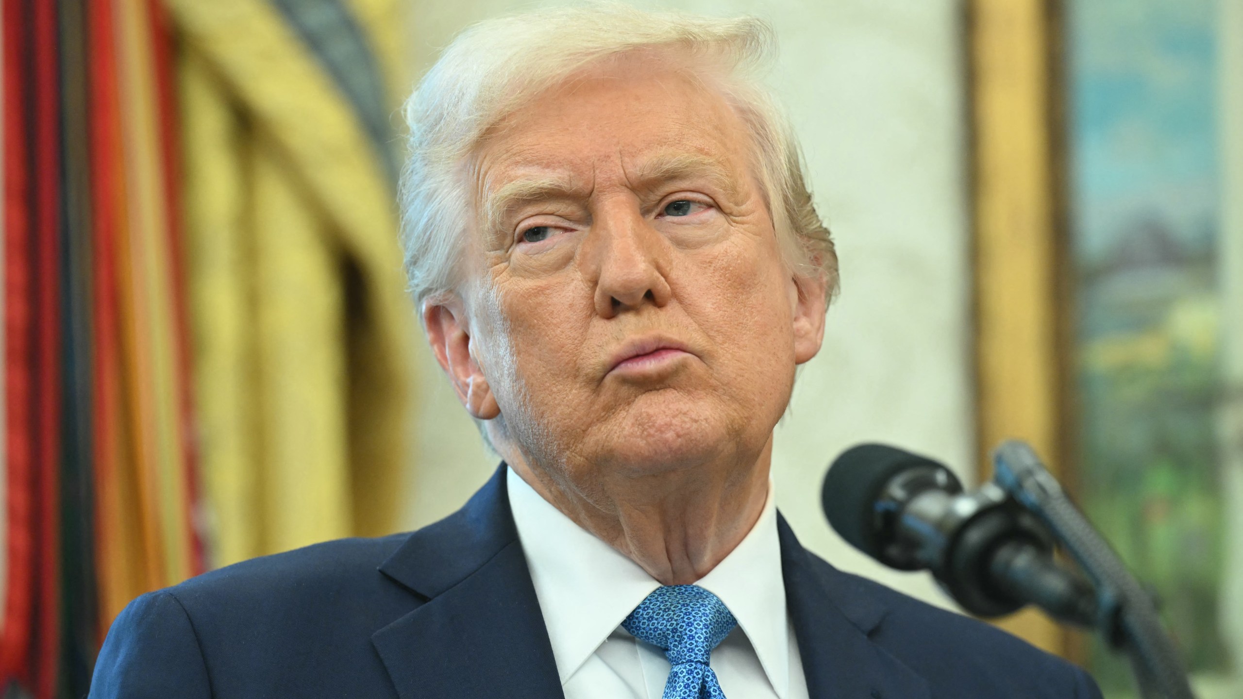Trump speaks from a podium in the Oval Office