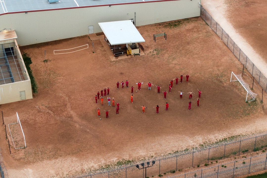 People spell out SOS with their bodies in the courtyard of a detention center
