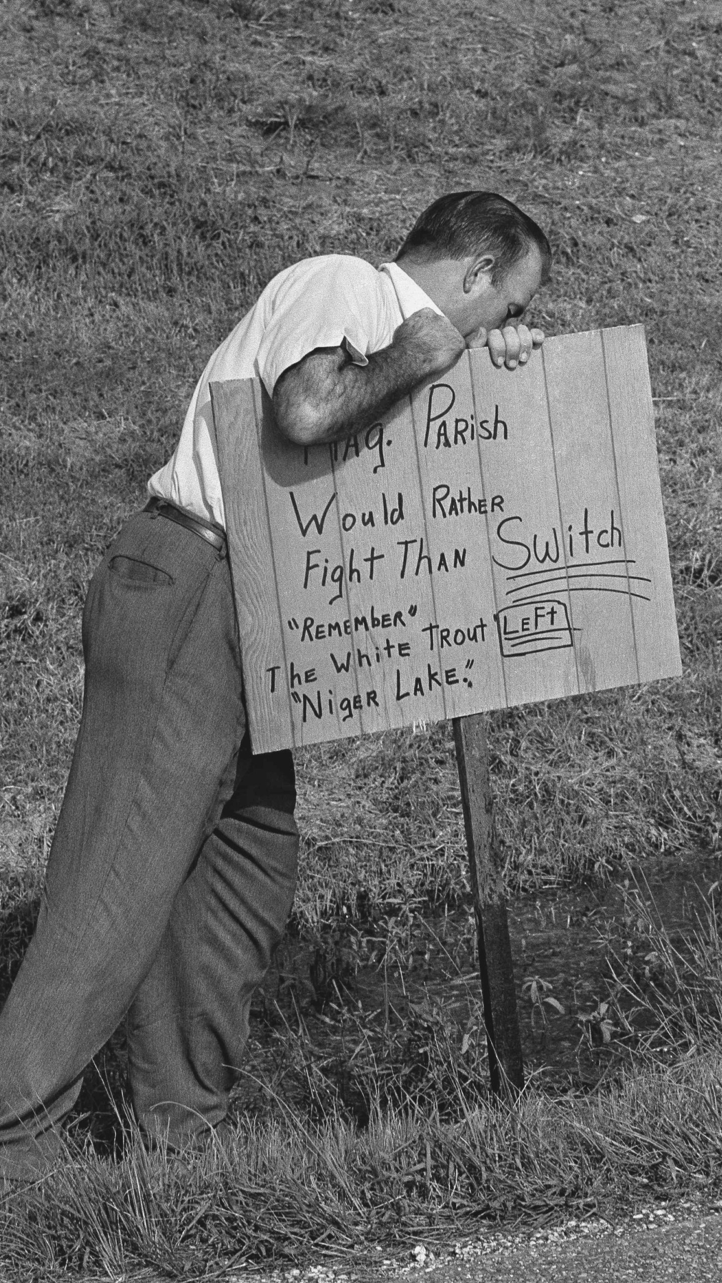 FILE - A man plants a sign reading outside Woodlawn High School in Pointe a la Hache, Louisiana on Sept. 1, 1966 where five African Americans applied for registration for the first time in parish history. (AP Photo/Jack Thornell, file)
